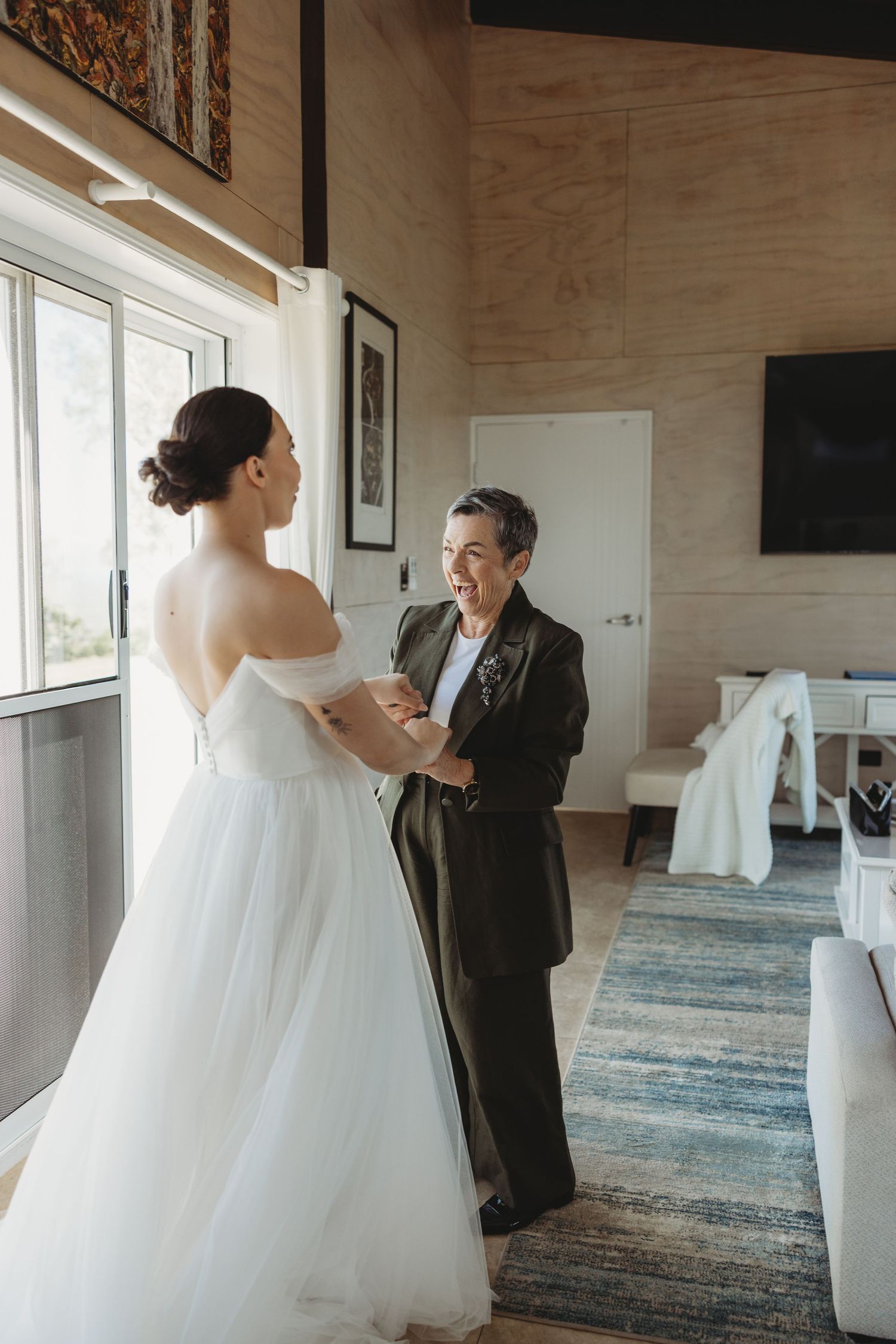 Wedding first look sequence showing tender reactions in a modern venue with blue carpeting.
