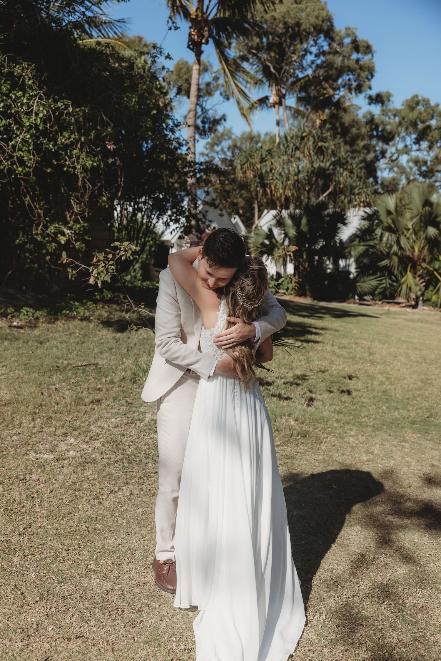 A romantic dance sequence between newlyweds in a sunlit outdoor setting.