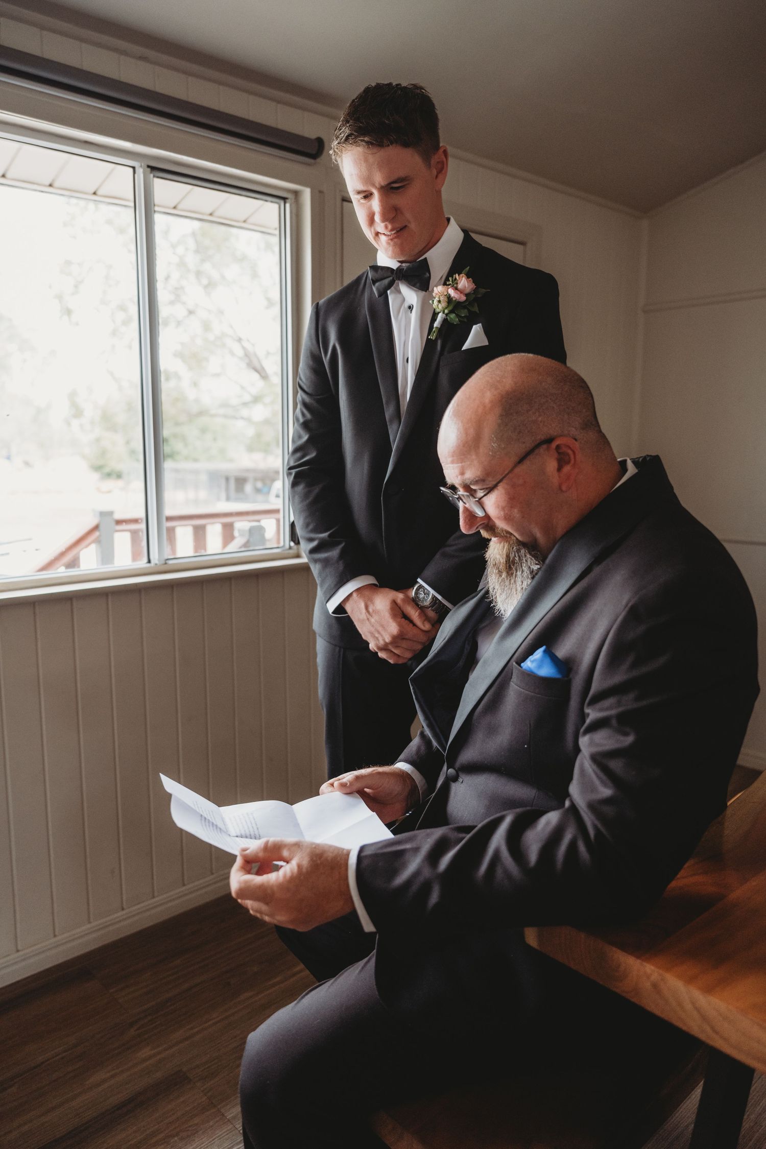 Wedding party members reading letters in a quiet indoor setting.
