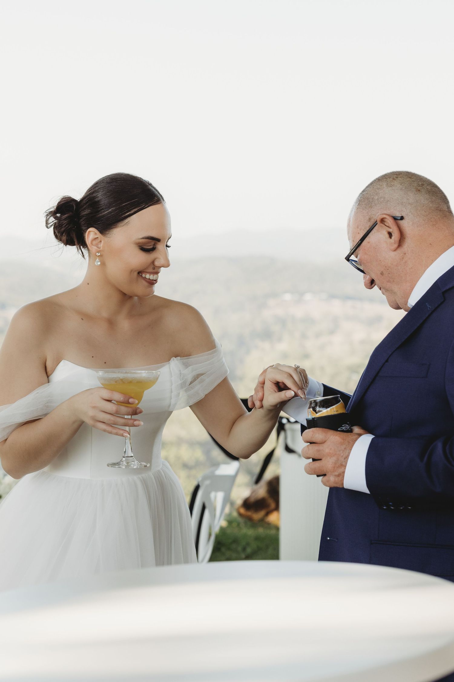 Couple shares drinks during an intimate wedding moment with scenic views.