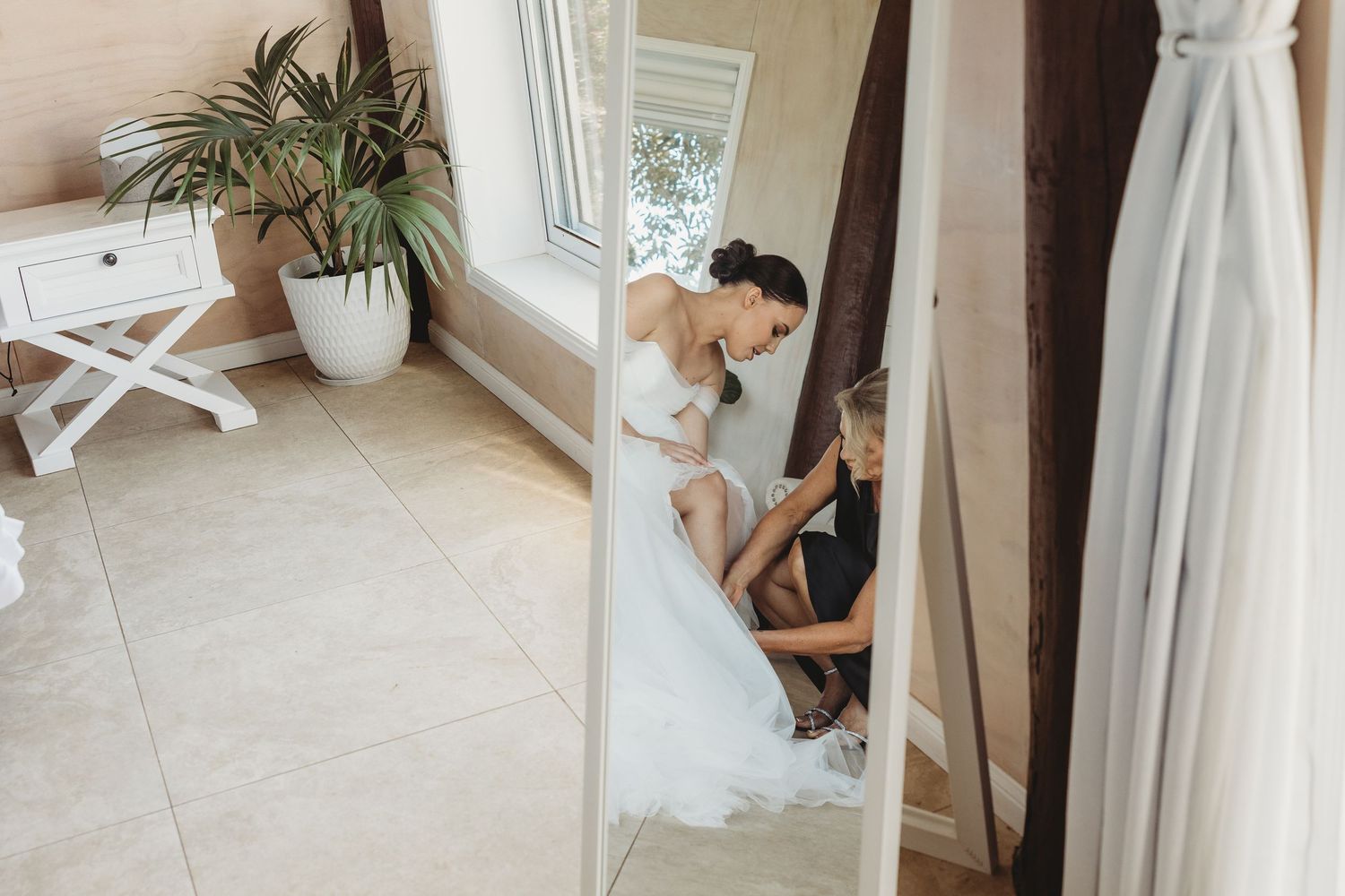 Behind-the-scenes preparation moments before a wedding ceremony in a bright room.