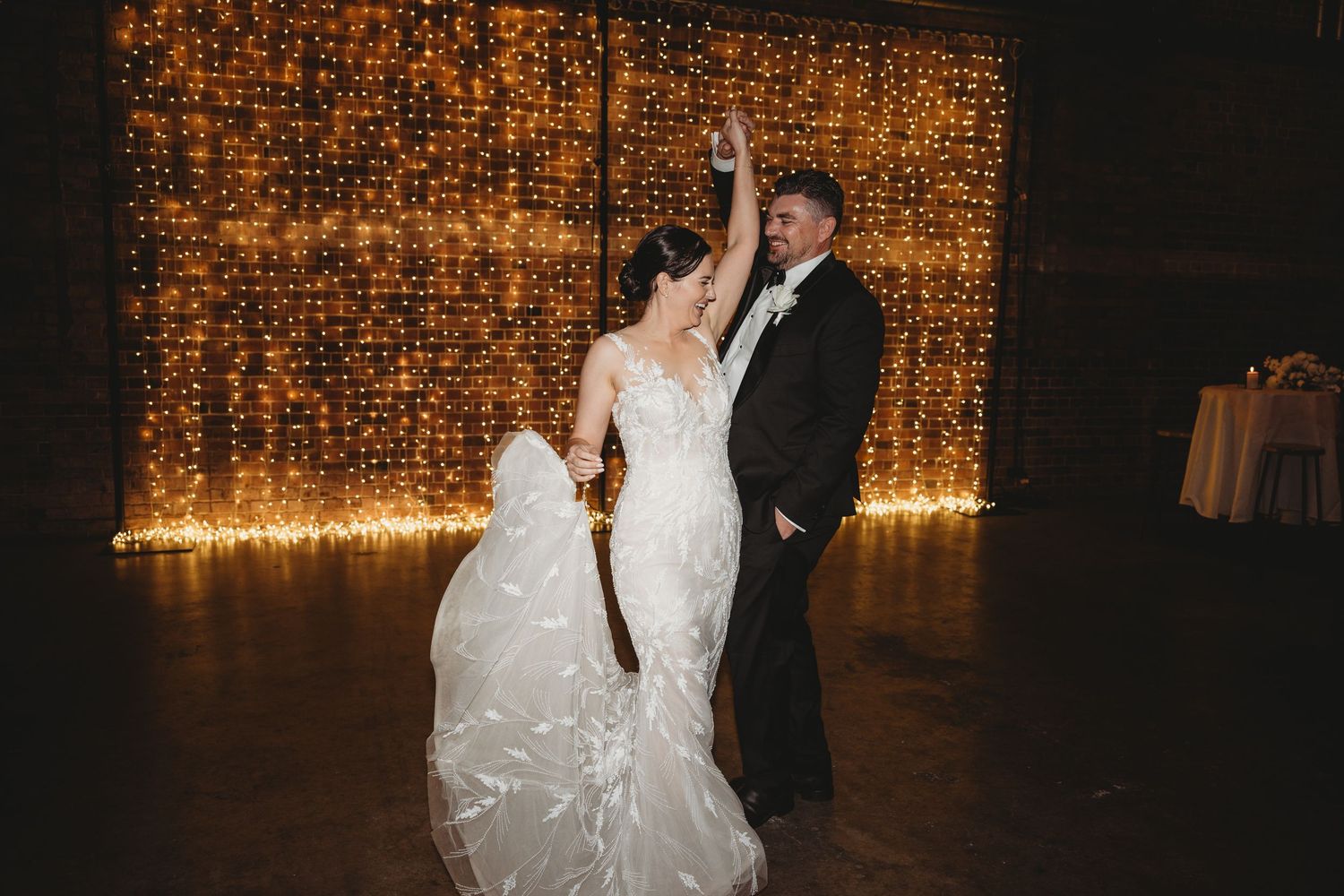 Romantic wedding dance scene with twinkle light backdrop creating a warm glowing atmosphere.