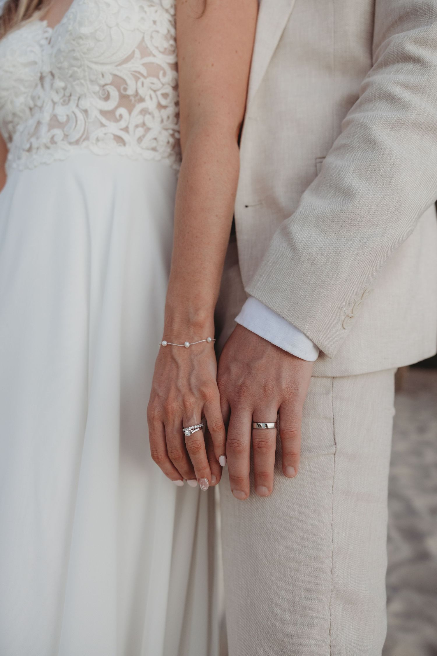 Close-up detail shots of hands wearing wedding rings and formal attire.
