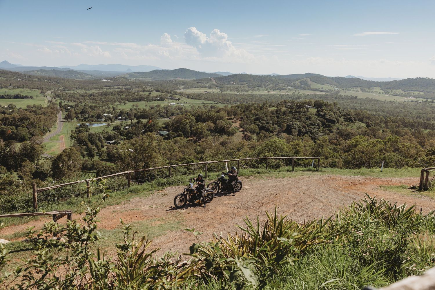 Scenic mountain landscape view with dirt paths and scattered vegetation.