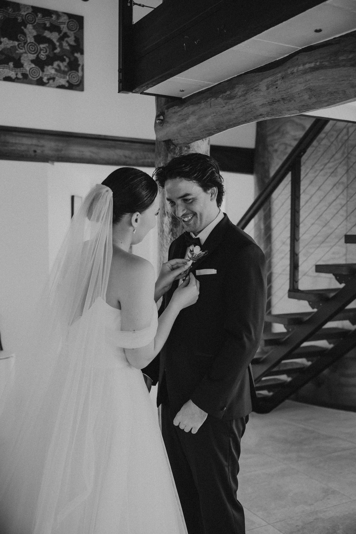 Black and white portrait of newlyweds sharing tender moments in an industrial-style venue.