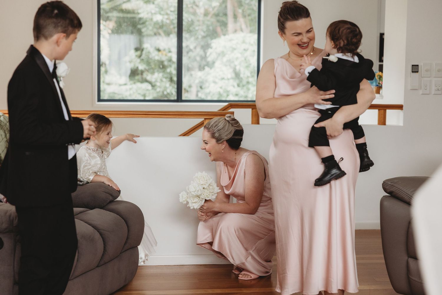 A sequence of tender moments between a couple and a baby during a formal occasion in a bright interior setting.