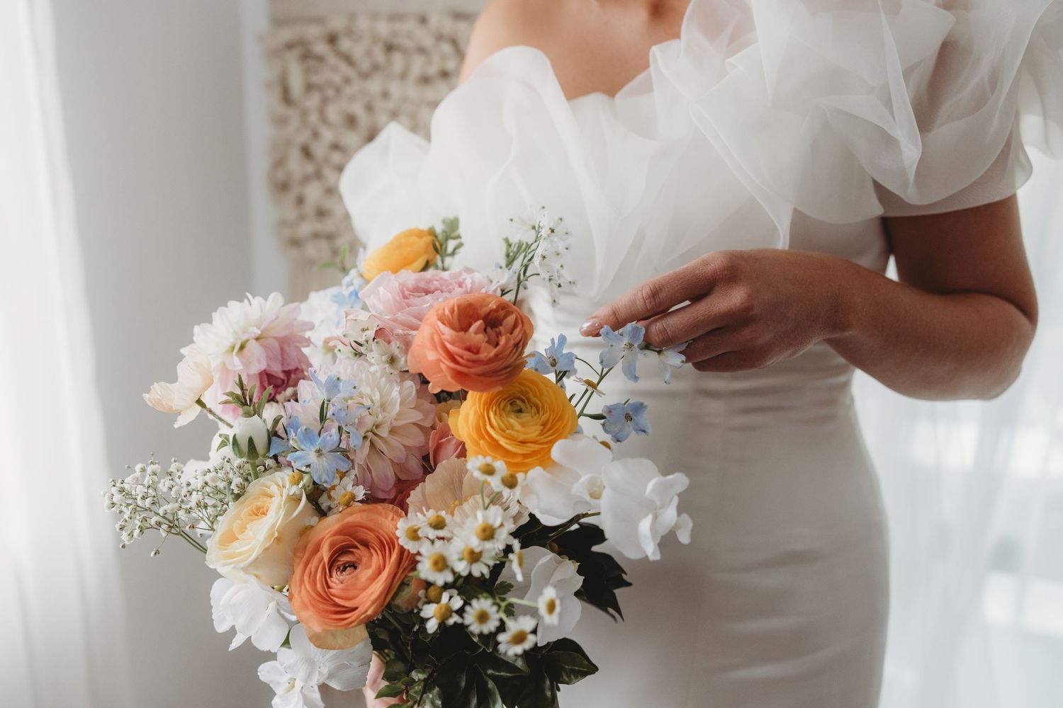 Close-up of wedding bouquets featuring peach roses and white flowers held by wedding party members.