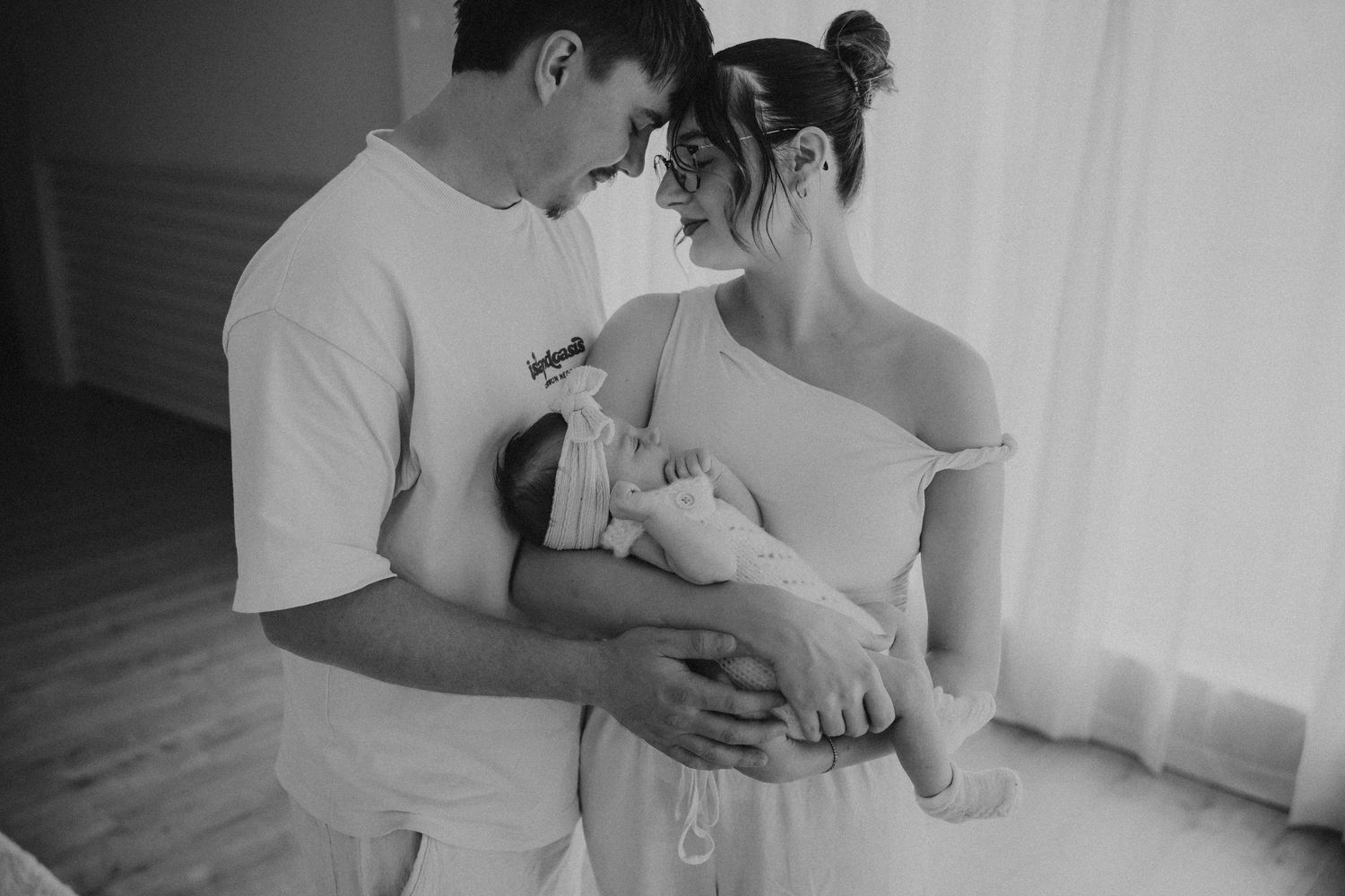 Intimate black and white portrait of new parents with their baby.