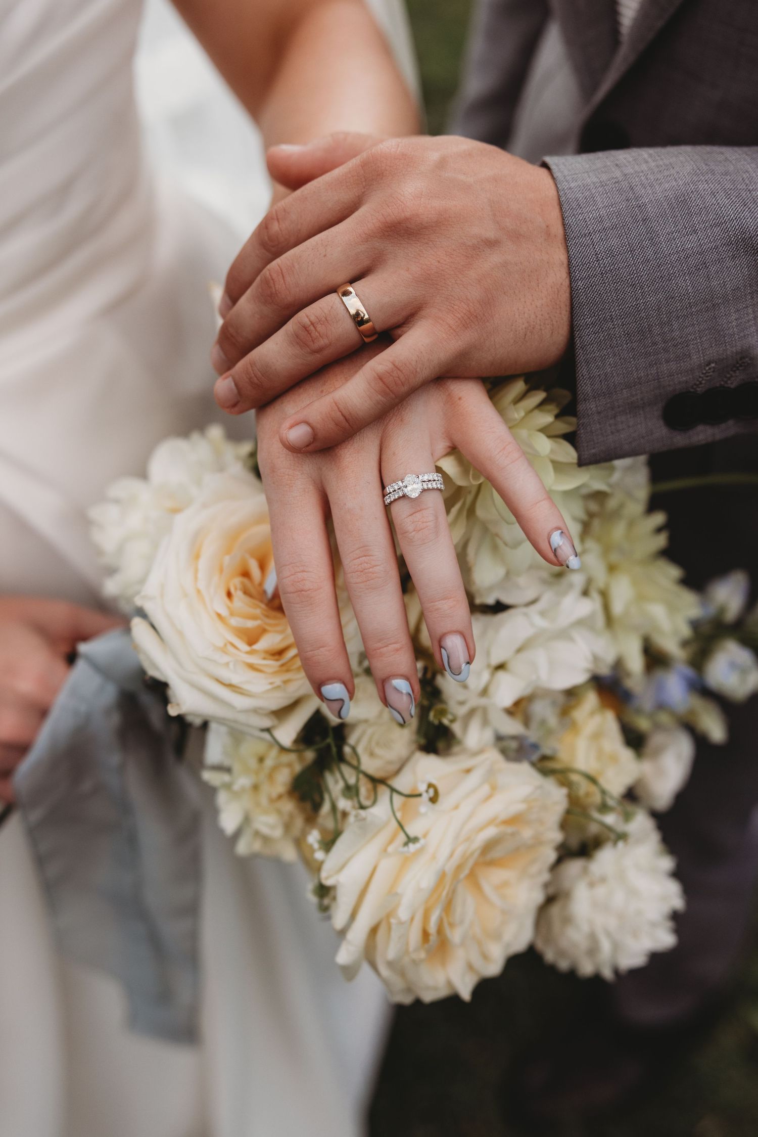Close-up of wedding rings and hands holding a white and cream floral bouquet Lilly & Lotus Botanical Gardens Wedding Portraits
