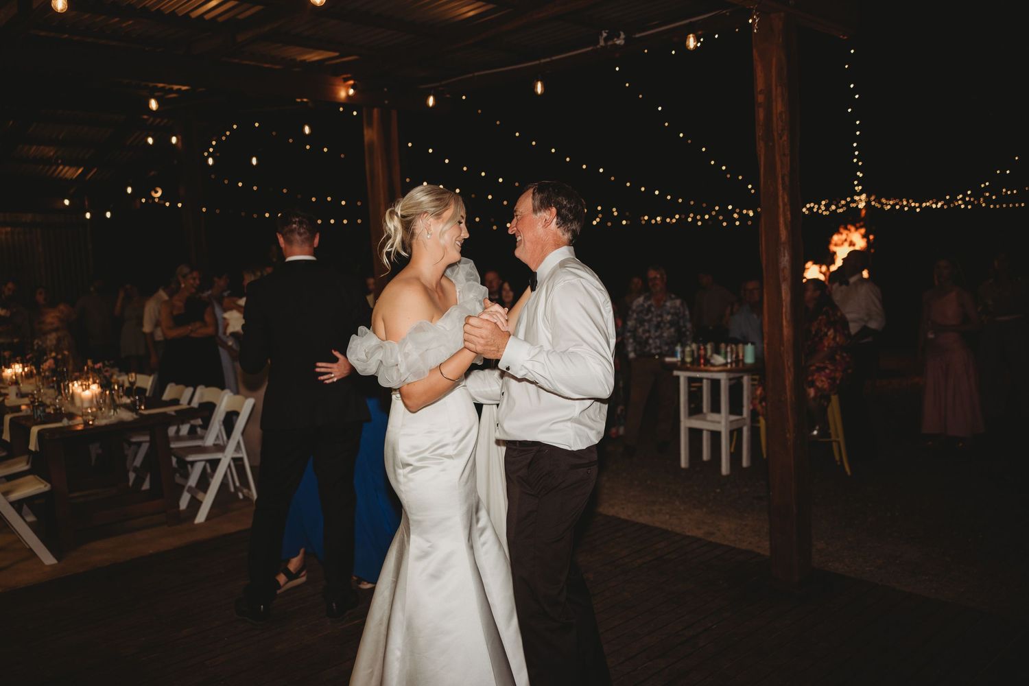 Wedding reception dance floor with string lights and guests enjoying the celebration.