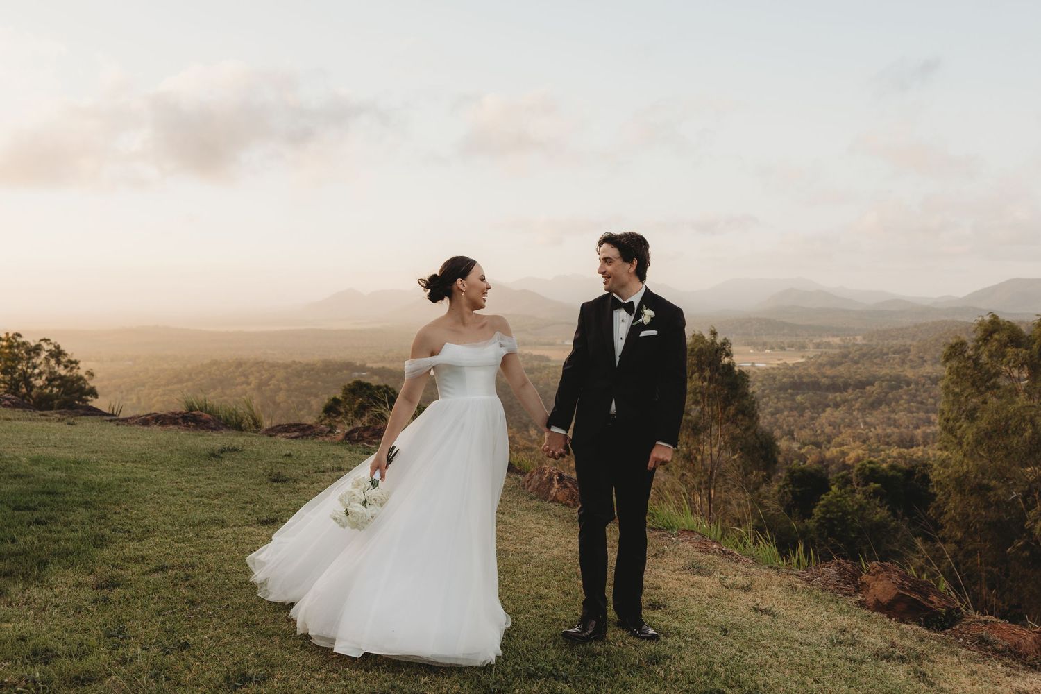 Elegant wedding photos captured on scenic mountain overlook at golden hour.