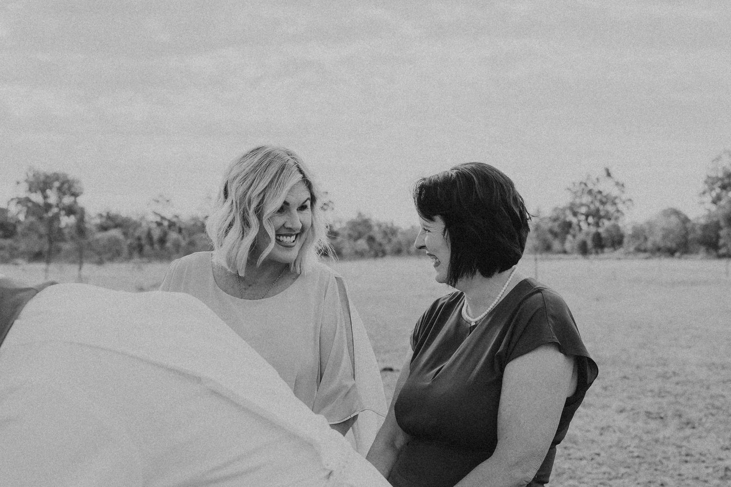 Candid moments between wedding guests during an outdoor celebration.