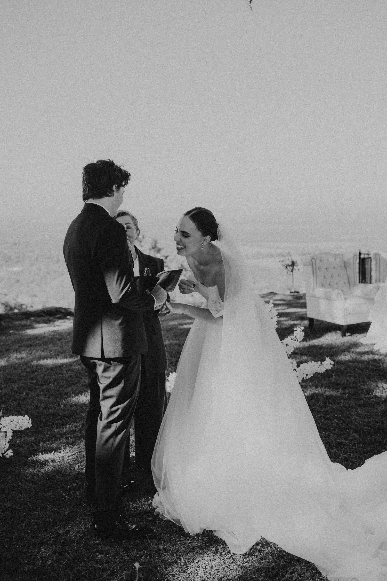 Black and white wedding photos showing intimate moments between newlyweds on a scenic overlook.