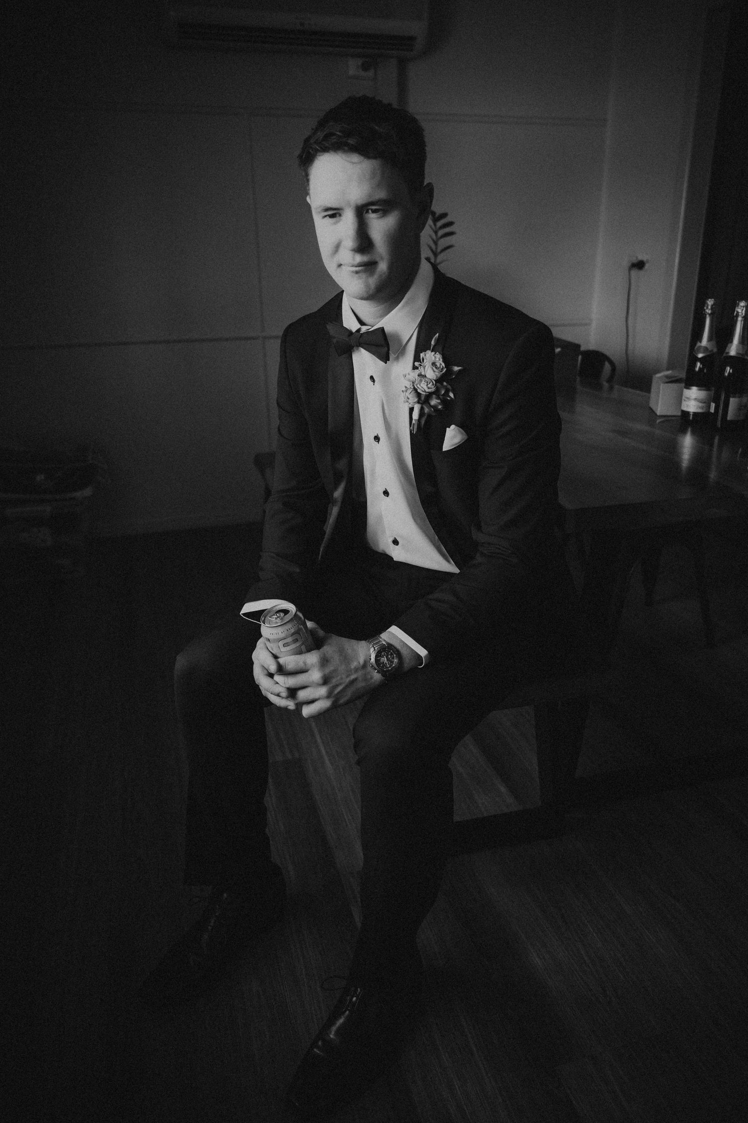 Dramatic black and white portraits of a groom getting ready in formal attire.