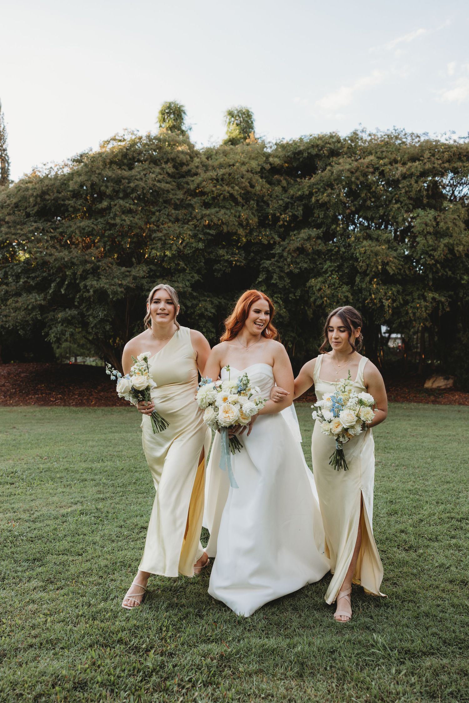 Bridal party in cream dresses laughs together on in portraits at Botanical Gardens