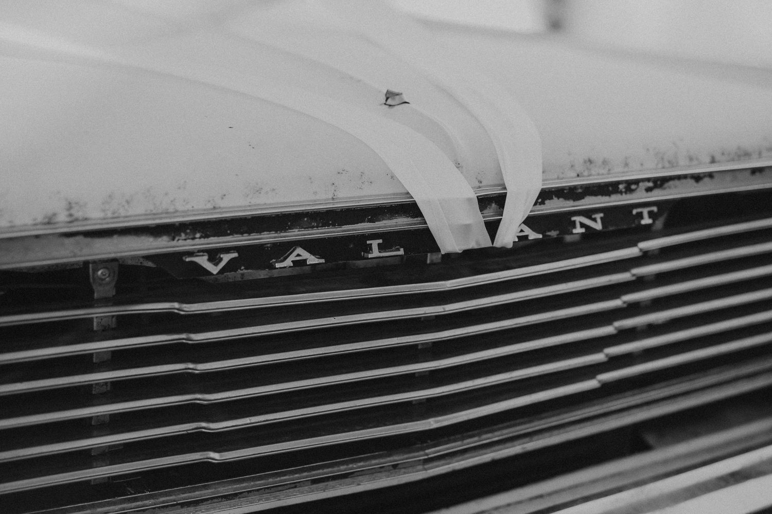 Close-up detail shot of vintage car grille with chrome lines.