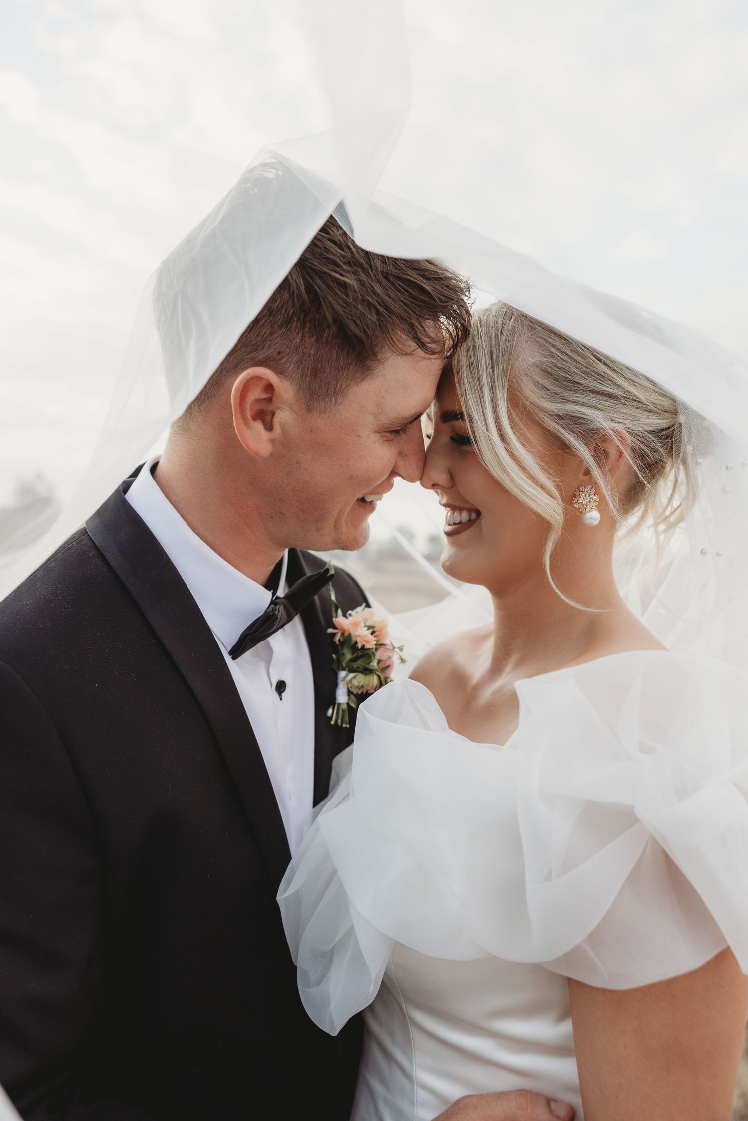 Intimate wedding portraits with couple sharing tender moments under a flowing veil.