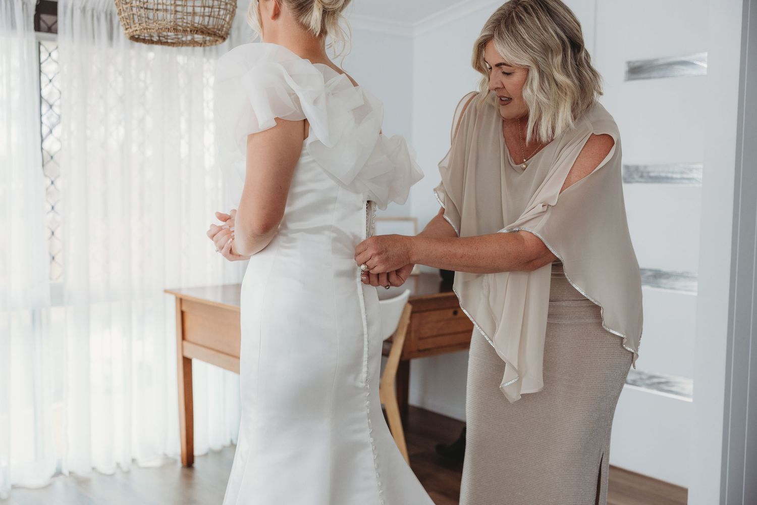 Wedding preparation moments captured in natural light with white decor.