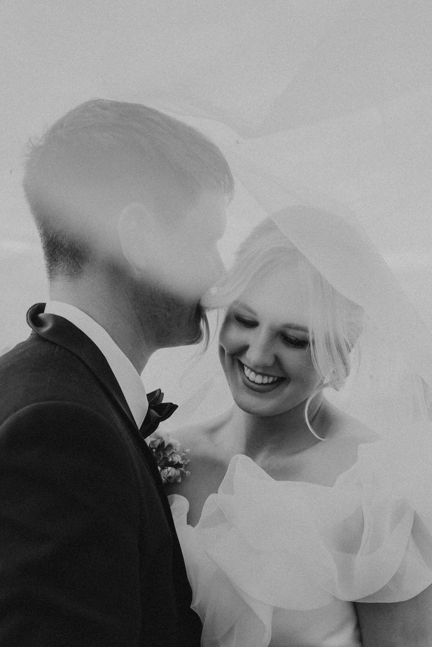 Artistic black and white close-up portraits through sheer wedding veil.