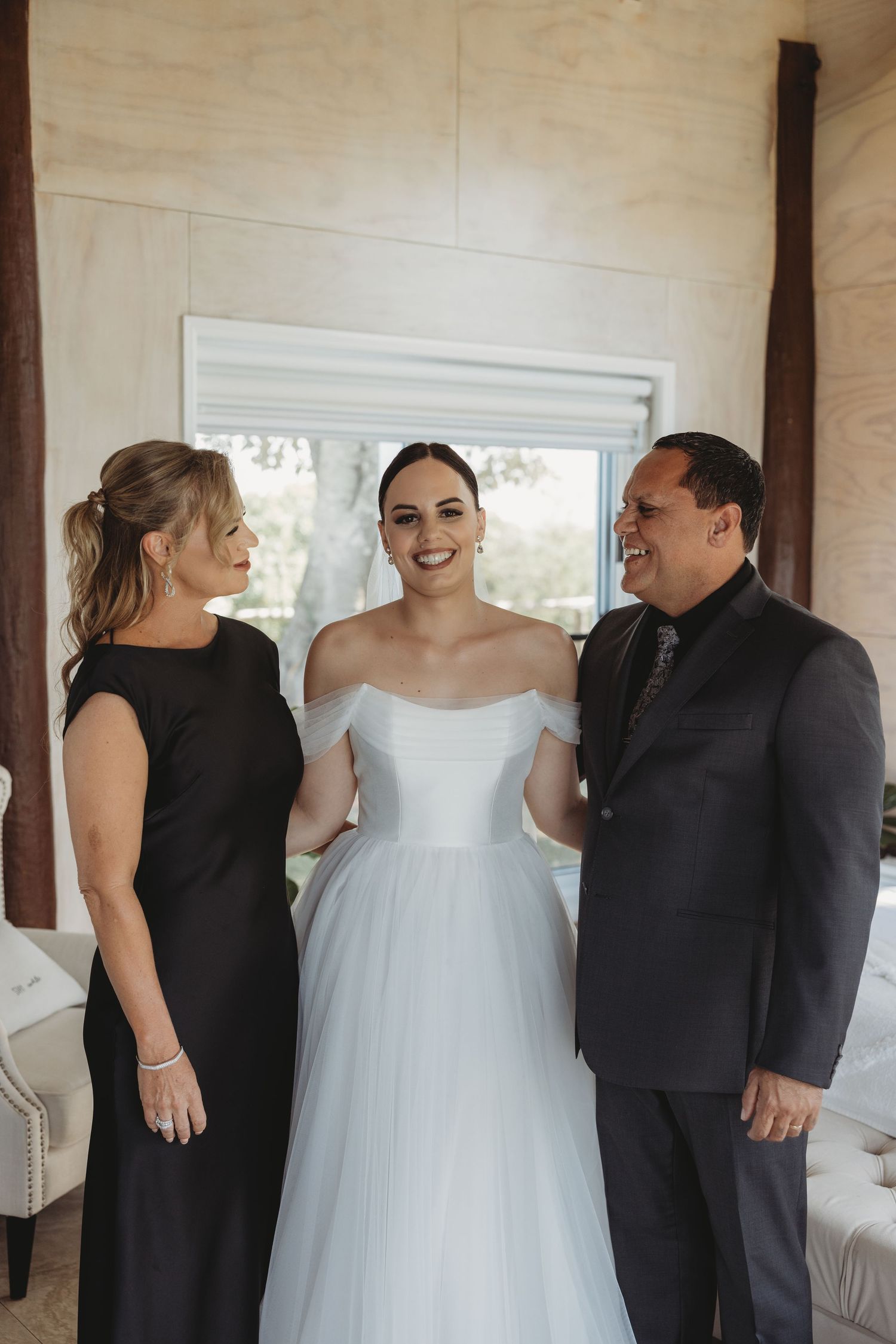 Wedding party in black and white attire sharing joyful moments before the ceremony.