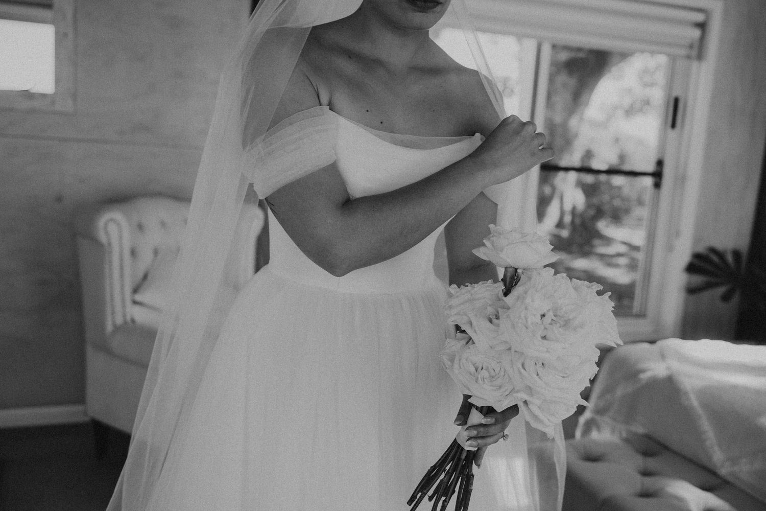 Wedding couple embraces in black and white portrait with soft natural lighting.