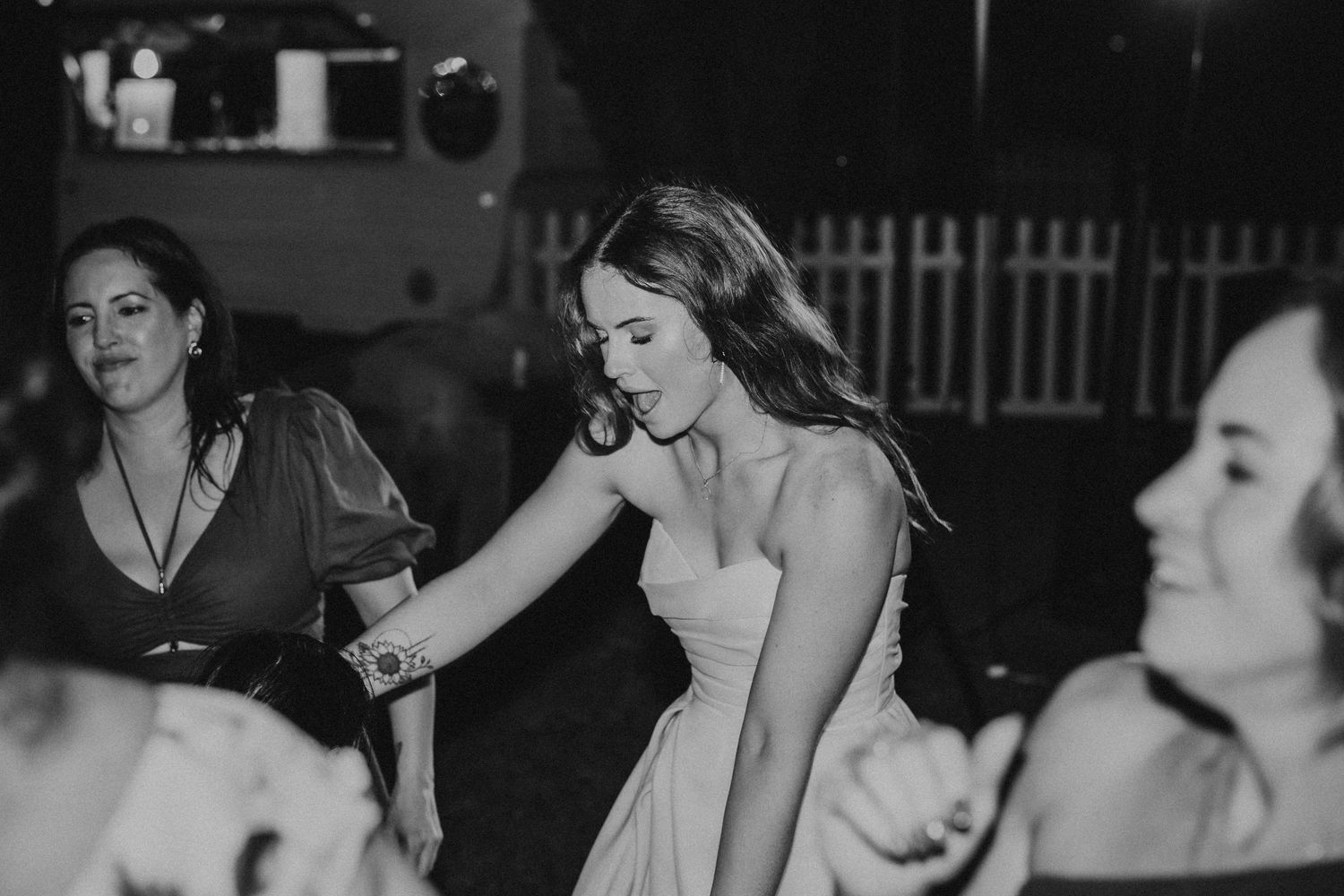 Black and white candid shots of wedding guests enjoying the reception festivities.