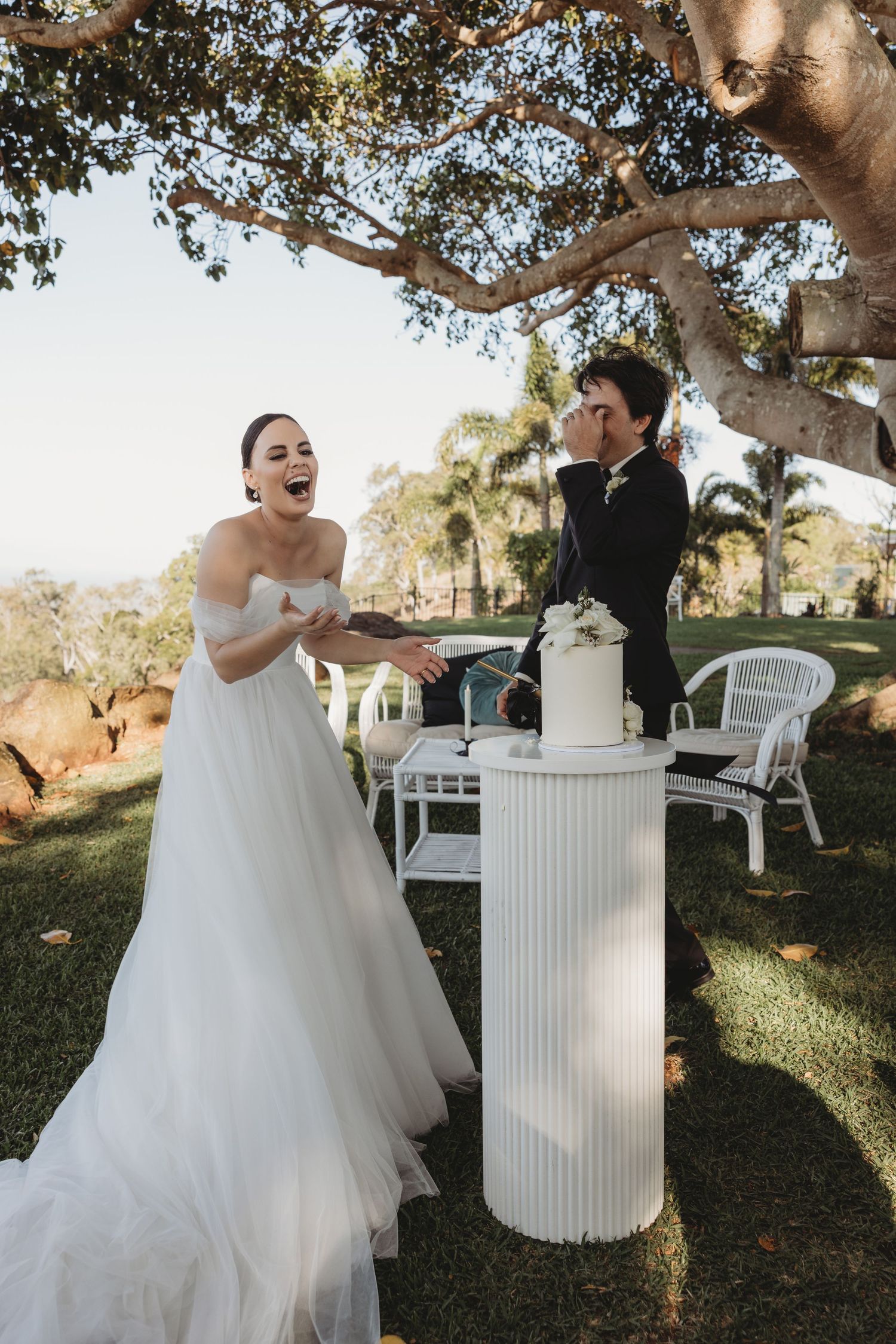 Candid wedding moments captured during an outdoor reception under a large tree.