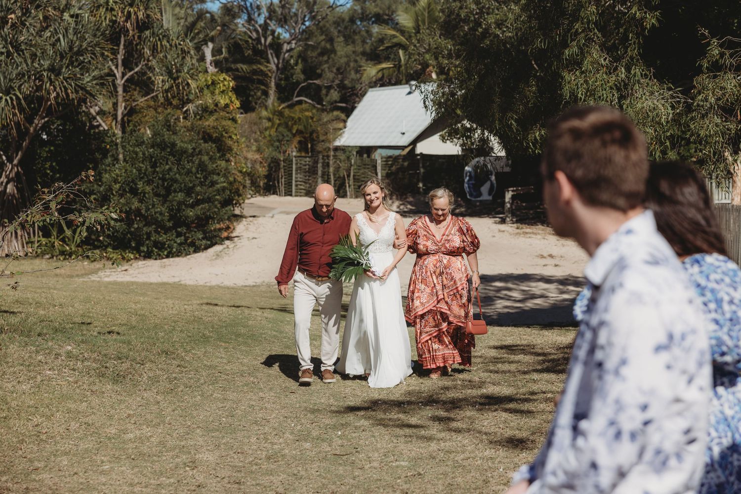 Wedding attendees walking and socializing on outdoor grounds.