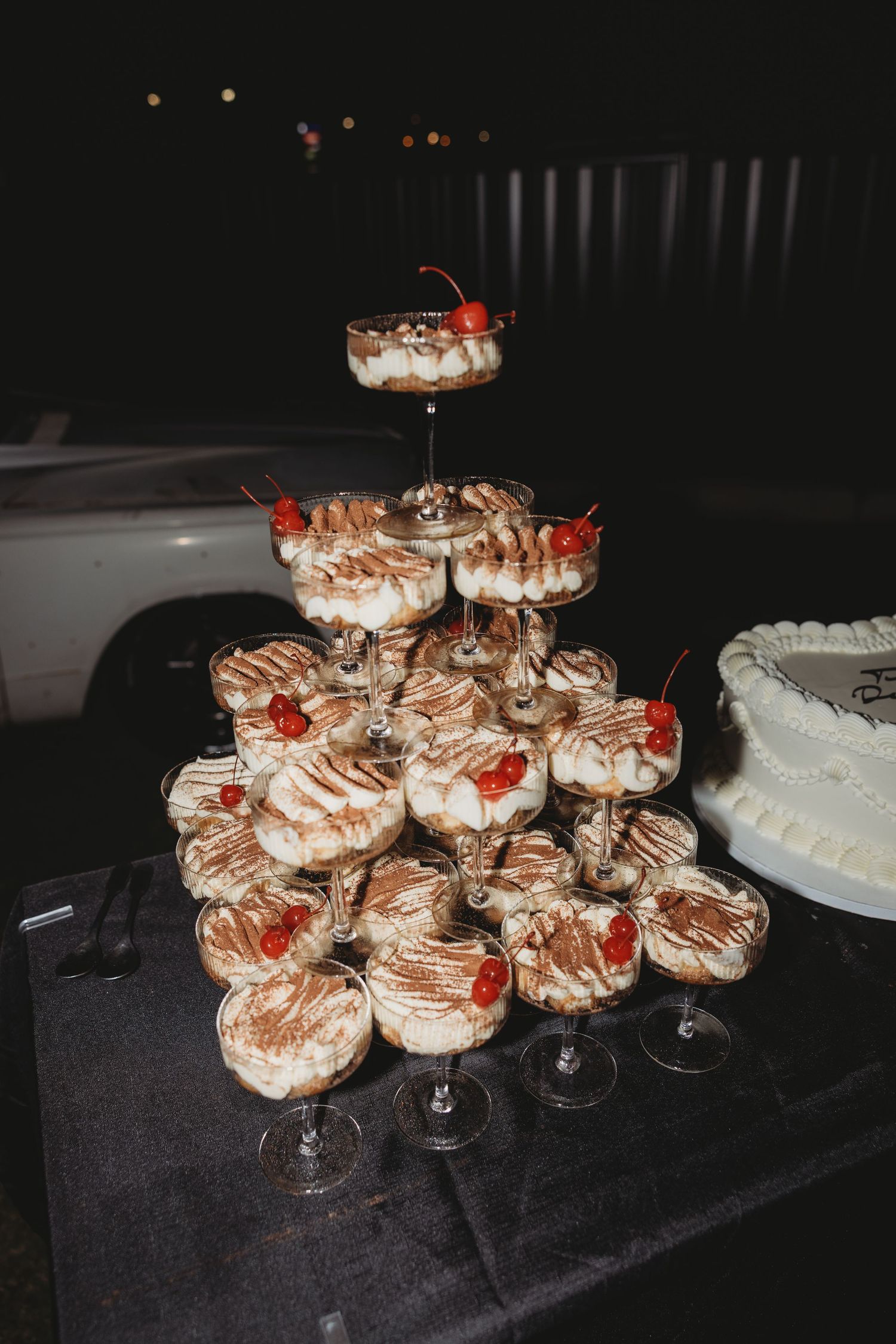 Elegant dessert display featuring tiered chocolate-topped treats with cherry garnishes.
