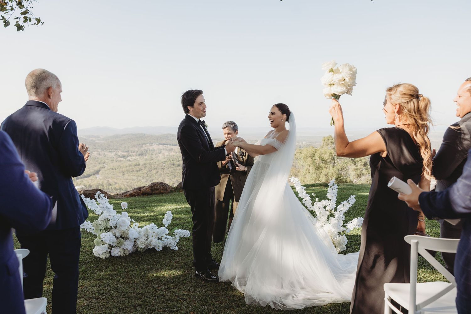 Wedding celebration captured outdoors with guests and the couple enjoying scenic mountain views.