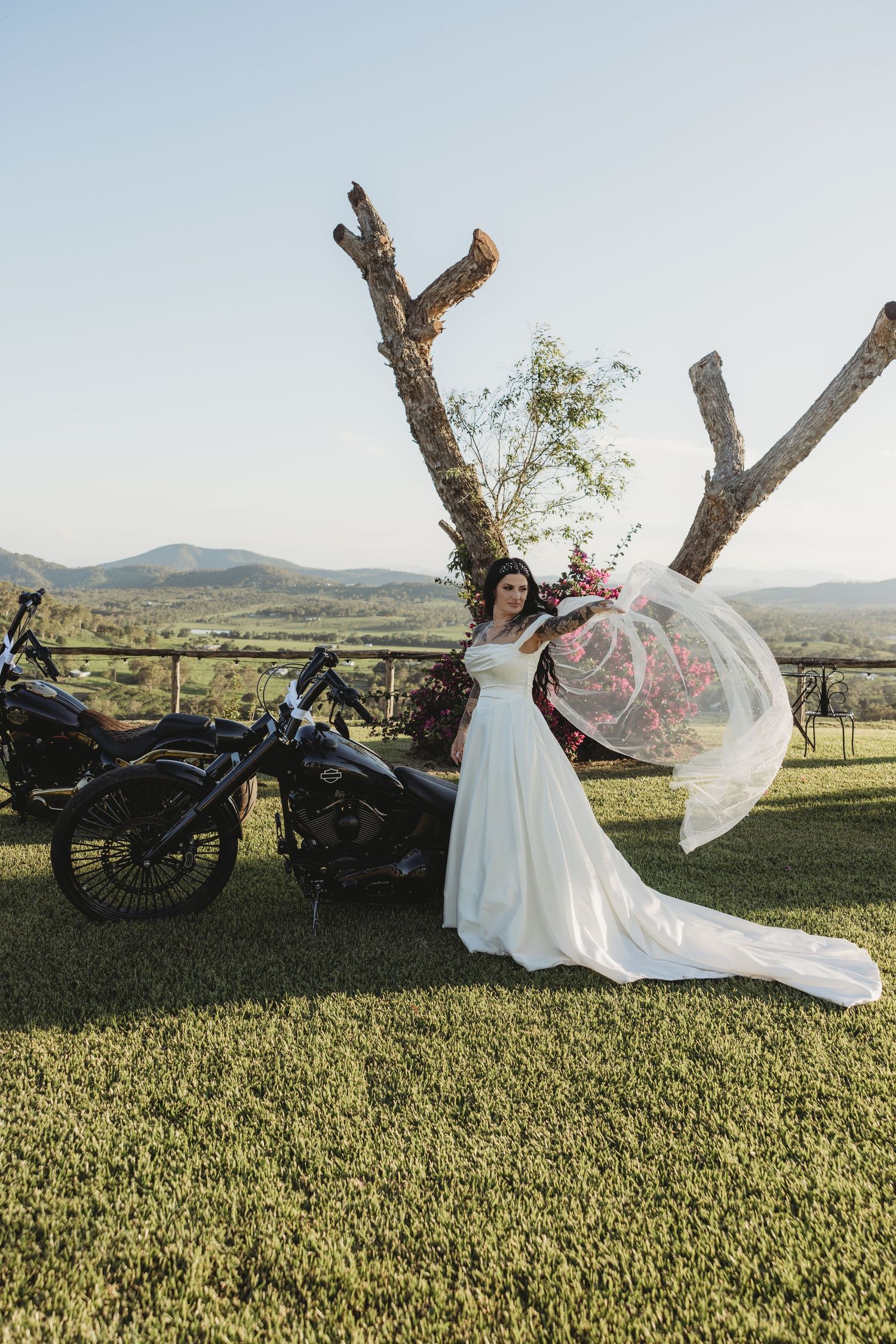 A wedding dress flowing in the wind during an outdoor photoshoot with mountains in the distance.