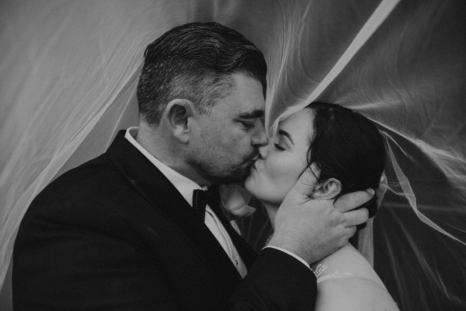 Intimate black and white wedding photography sequence showing tender moments under a veil.