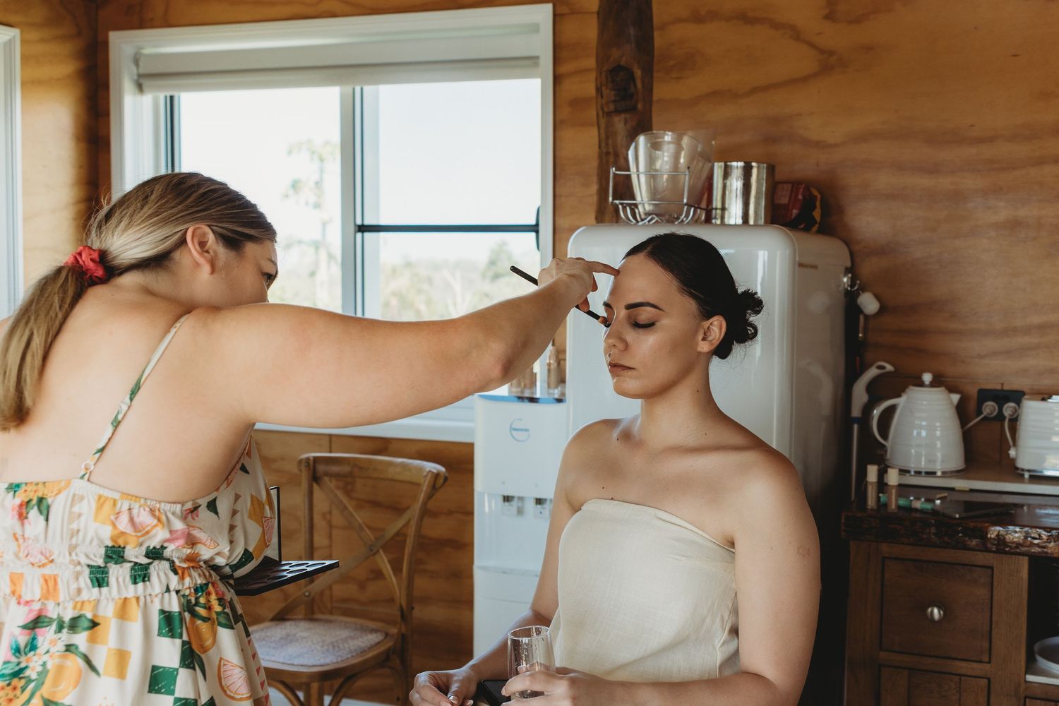 Getting ready scene in a wooden-paneled room with natural light streaming through windows.