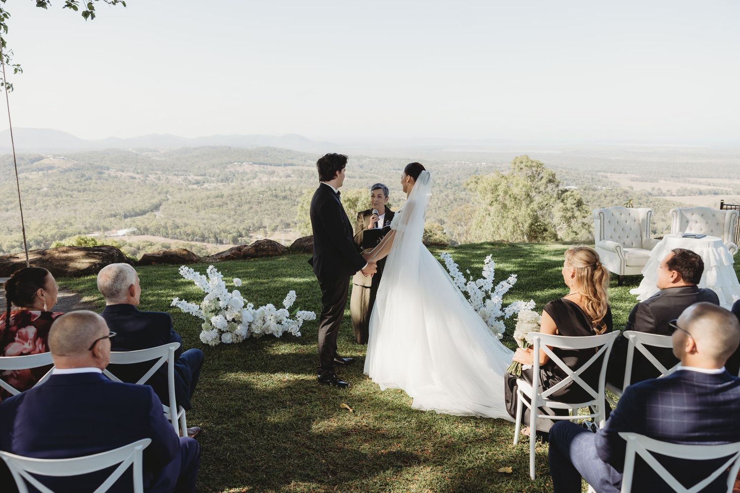 Wedding ceremony seating arranged on a grassy overlook with panoramic views of the valley below.