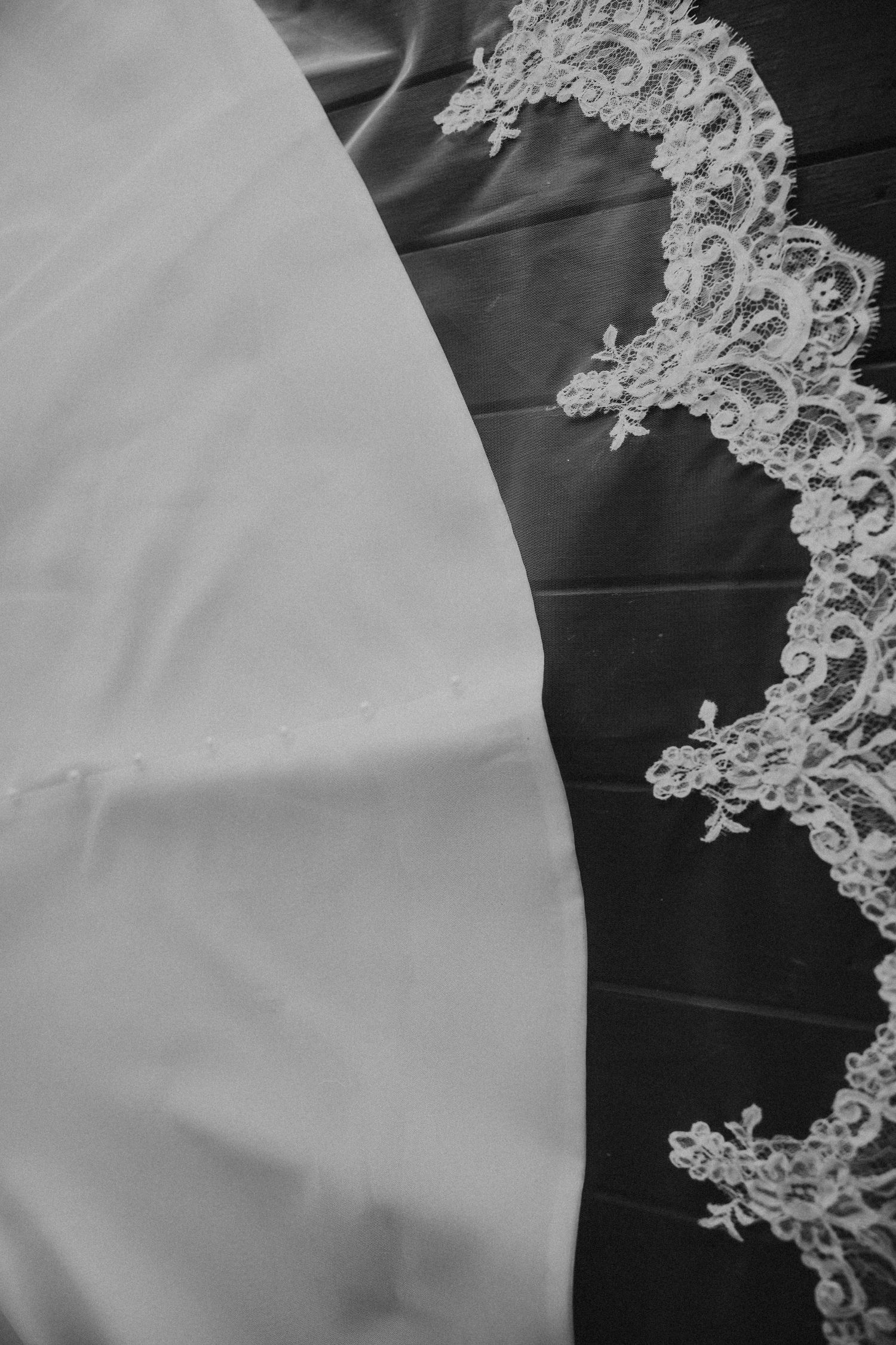 Close-up detail of delicate white lace trim on wedding dress fabric. St Aubins Rockhampton Wedding