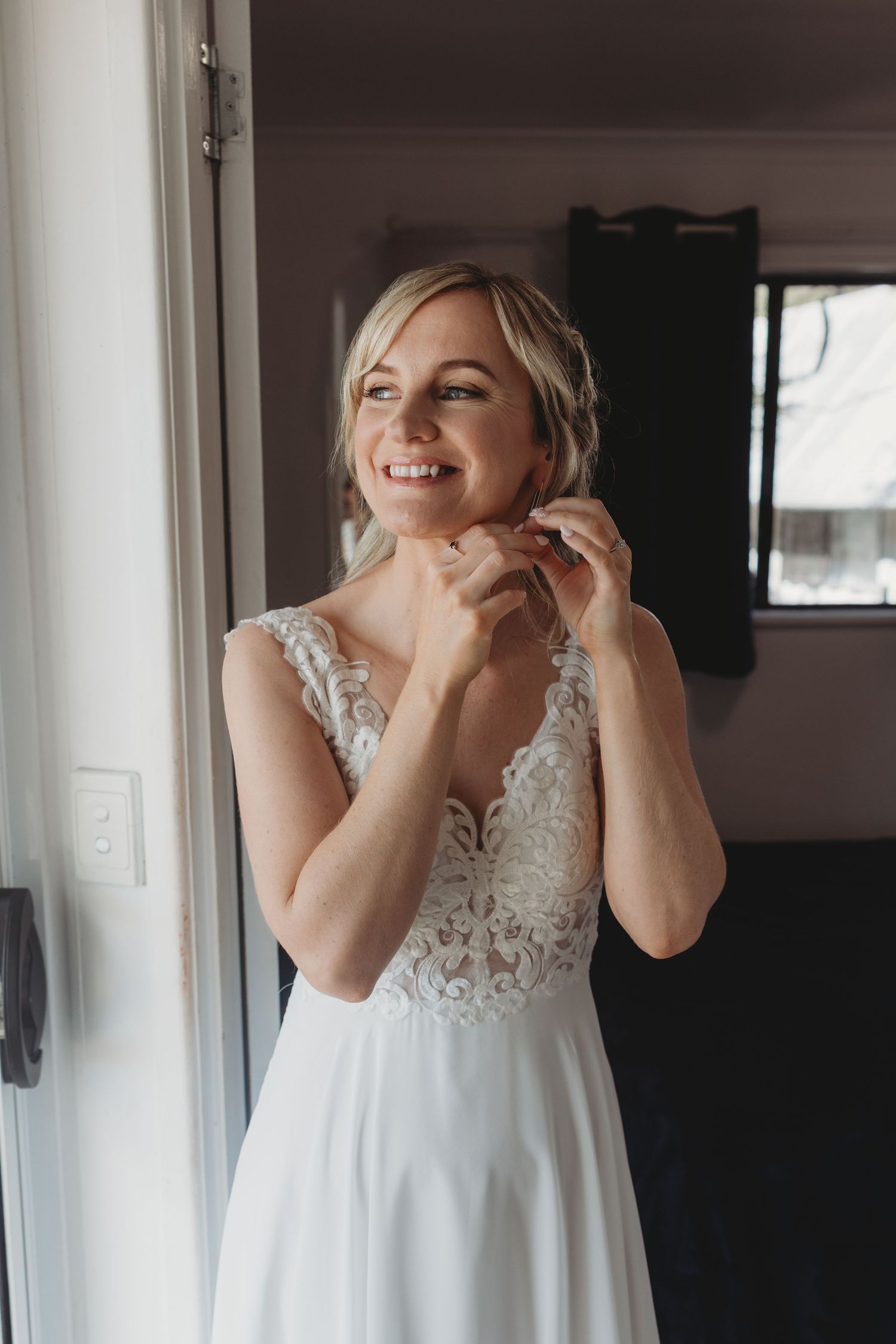 Elegant white wedding dress with lace bodice shown in natural window light.