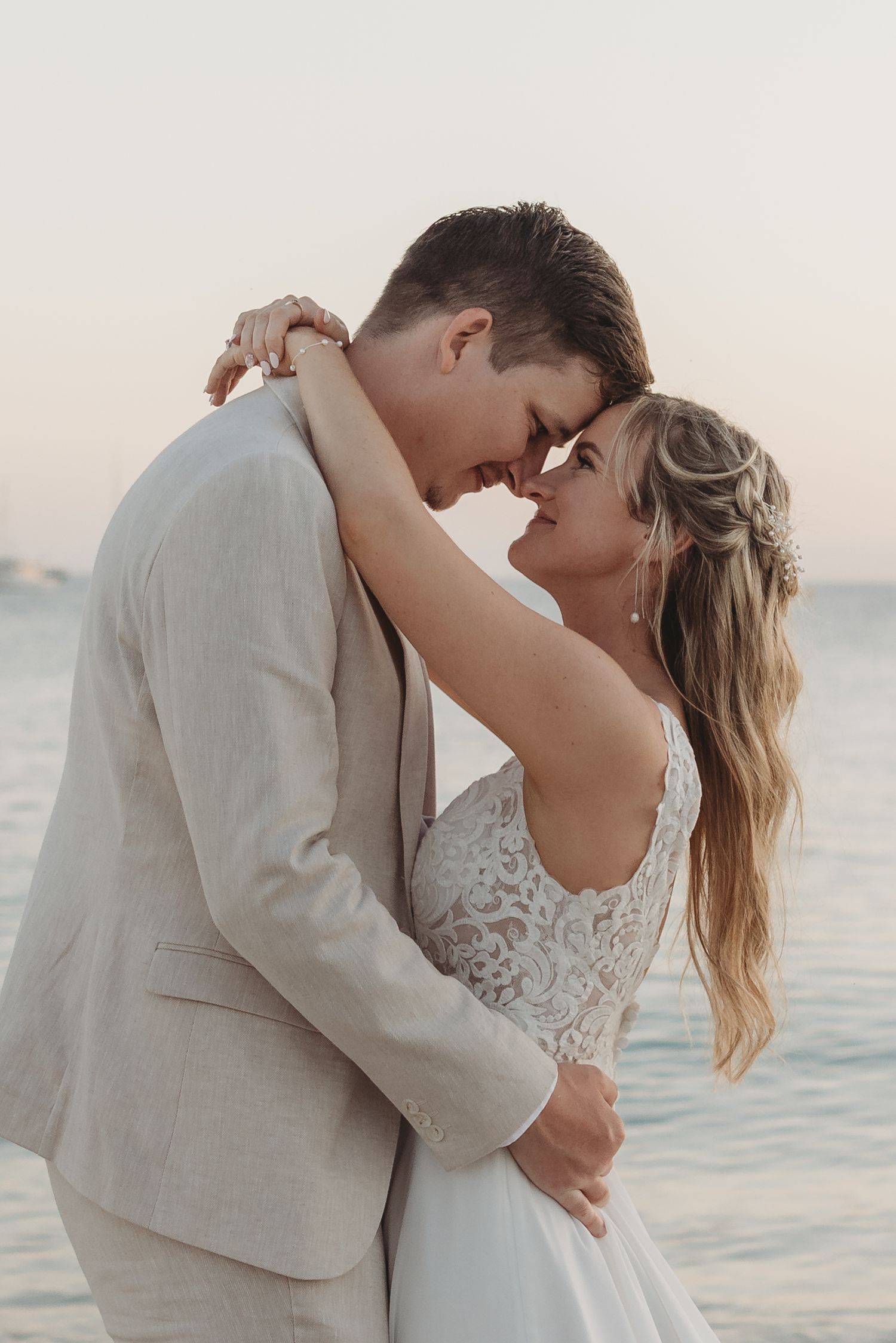 An intimate dance moment between a couple on the beach during golden hour.