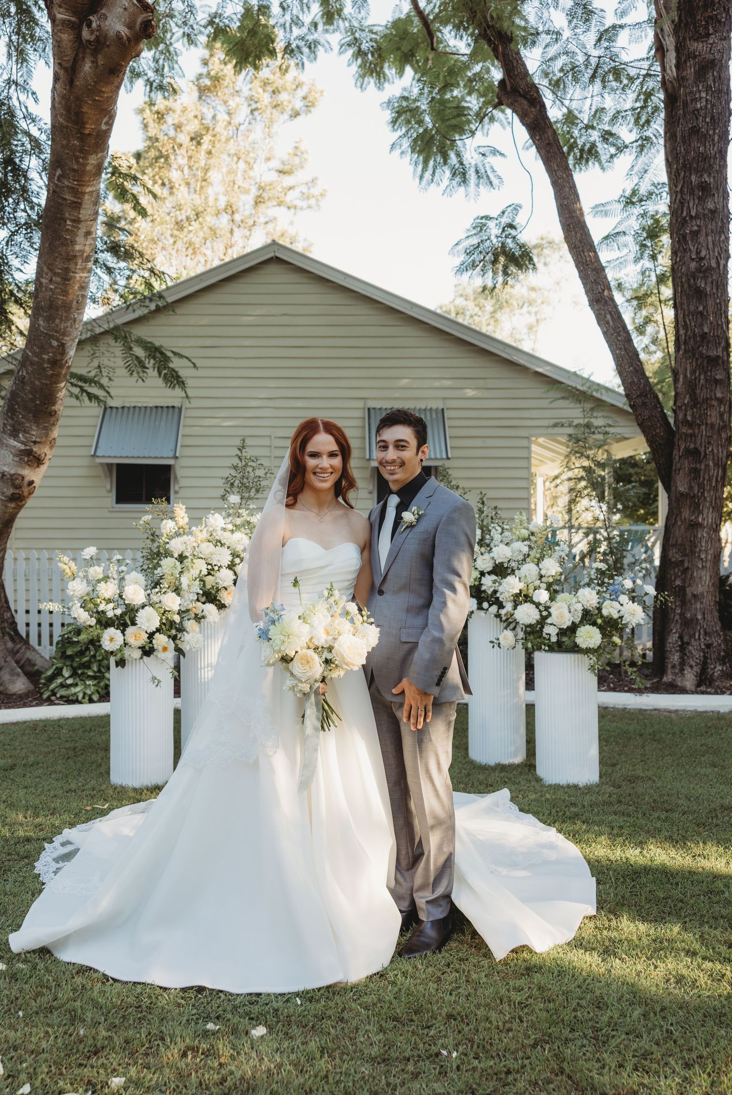 Wedding portrait of couple standing in front of white house with floral decorations St Aubins Wedding portrais