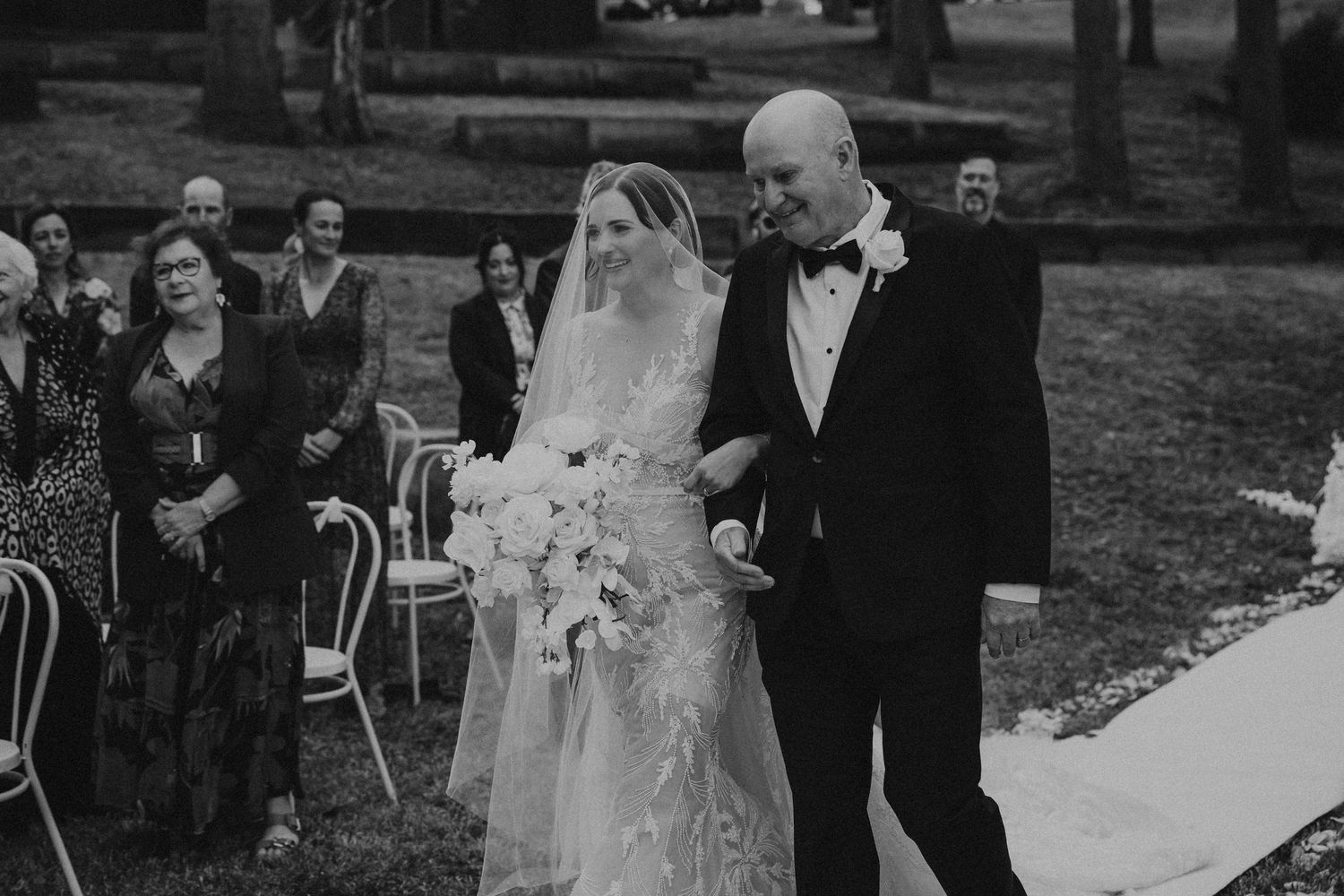 Black and white photo series showing wedding ceremony moments along white aisle runner.