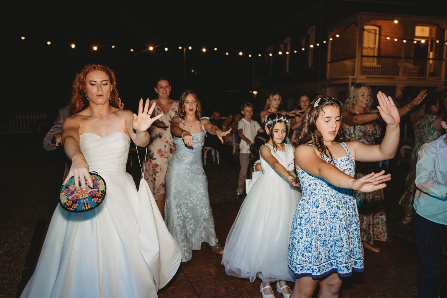 Wedding guests dancing and celebrating on an outdoor dance floor. Tamara Porter Photography