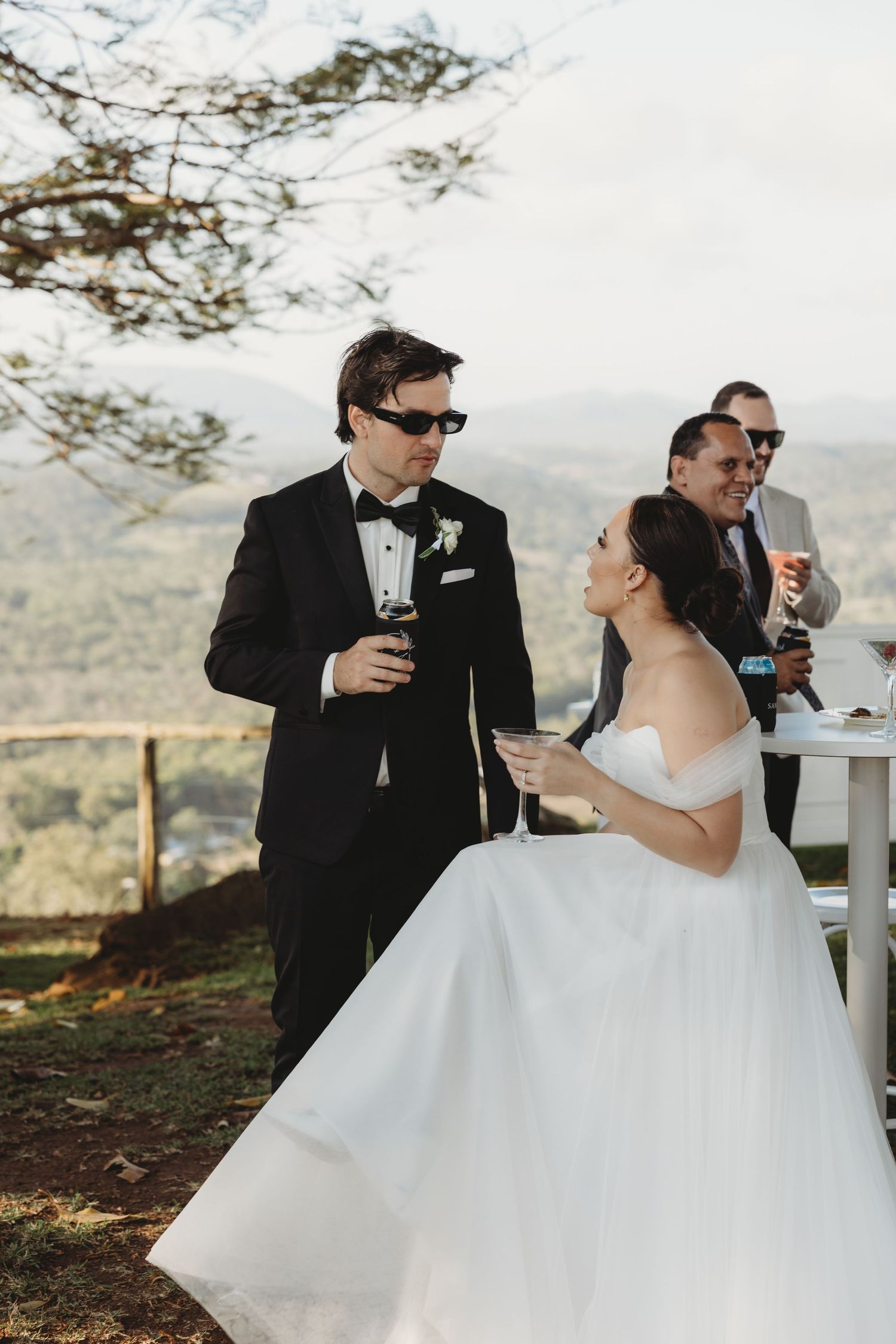 Elegant outdoor wedding reception with guests mingling on a scenic overlook.