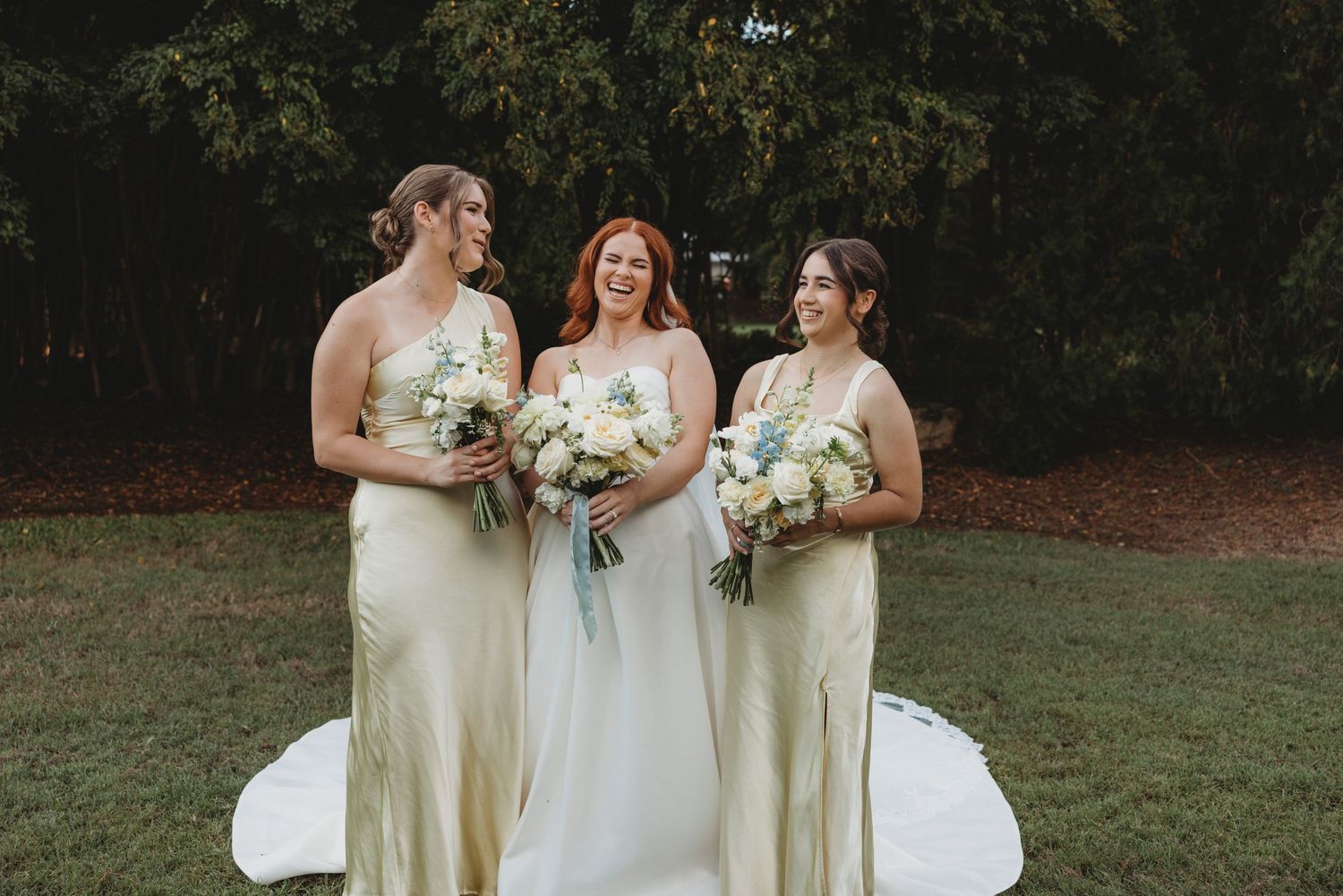 Bridesmaids in pale yellow dresses pose together on a grassy lawn Rockhampton Wedding