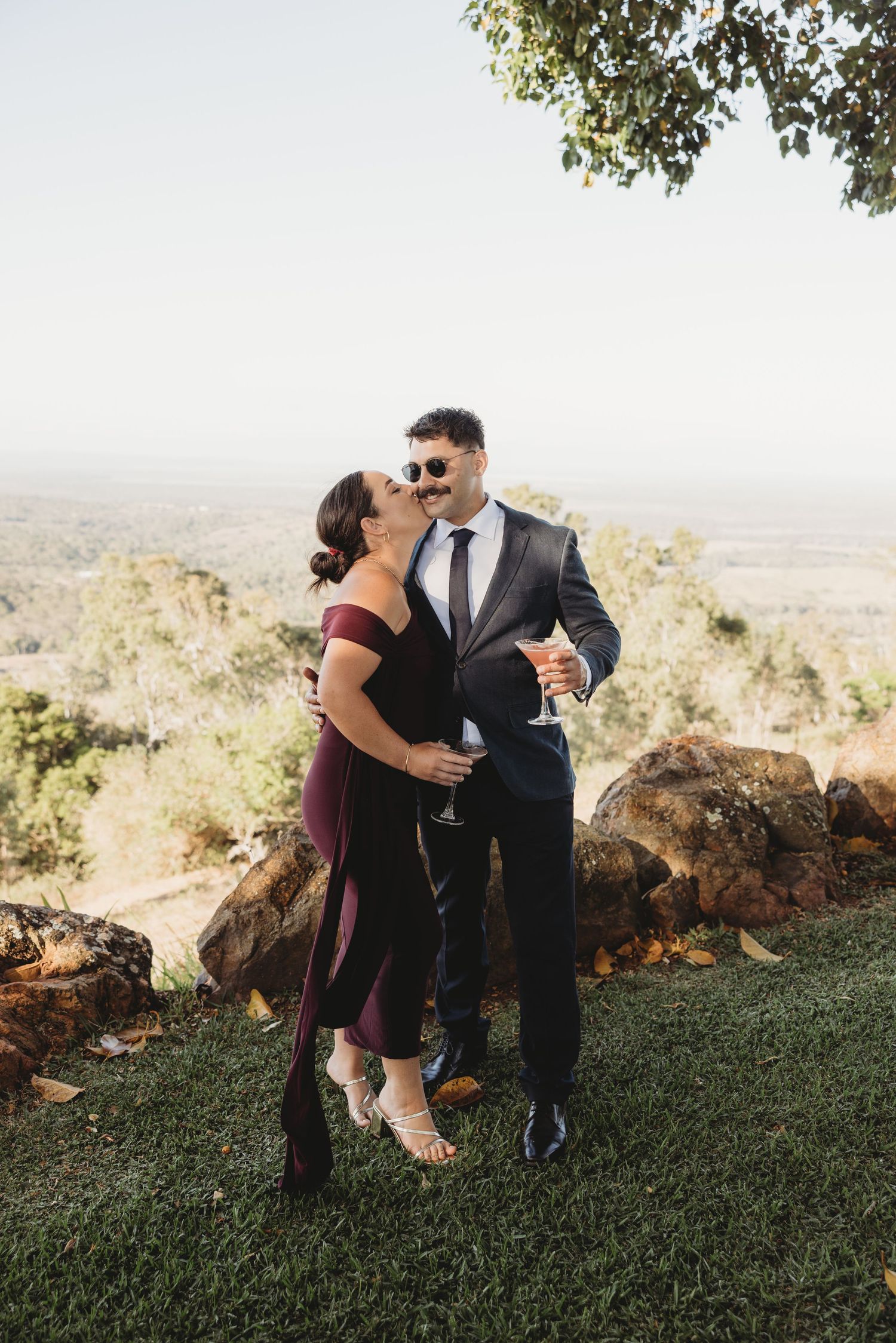 Couple shares romantic moments on a hilltop during golden hour at their wedding.