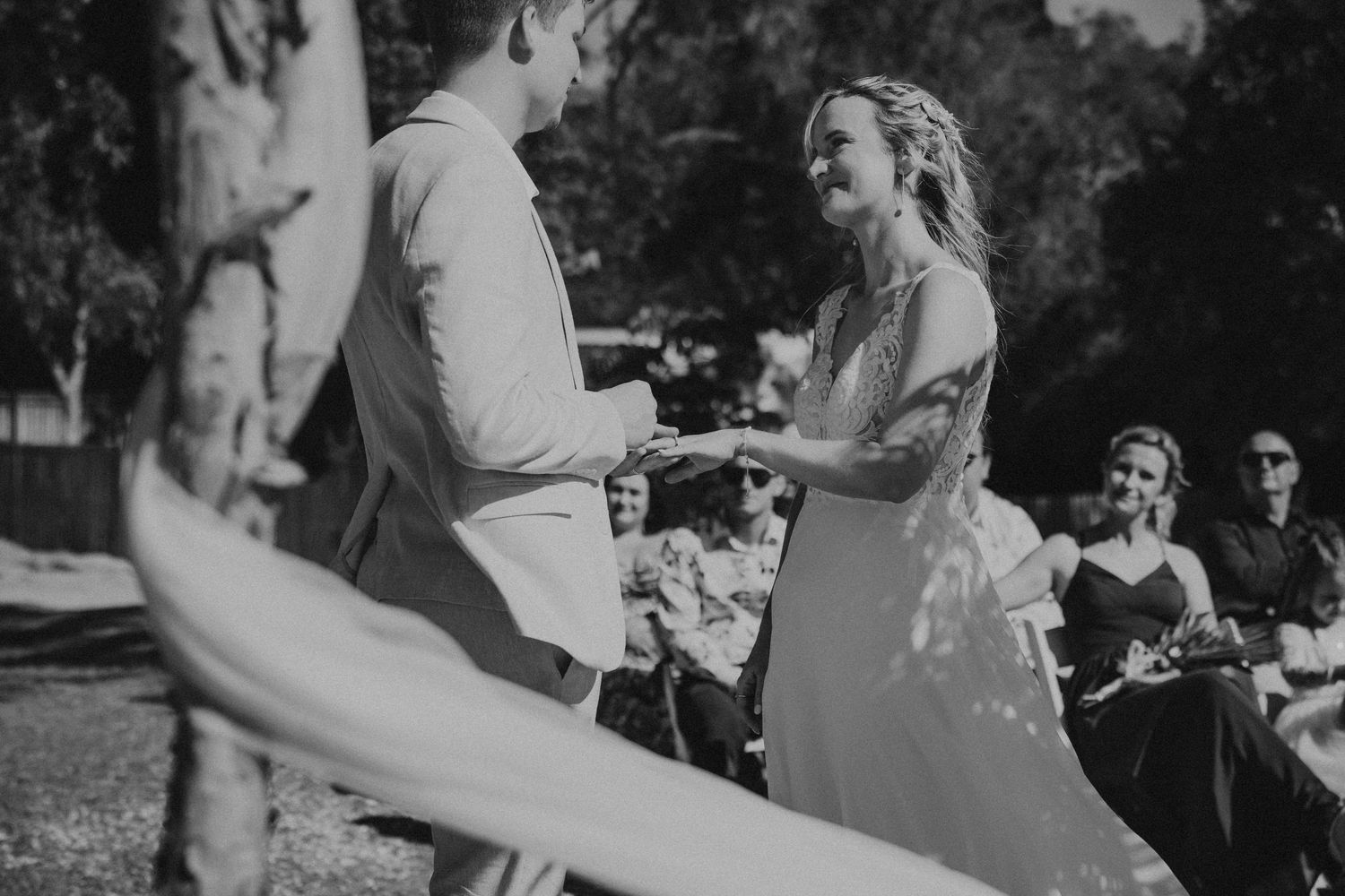 Black and white candid wedding moments during outdoor celebration.