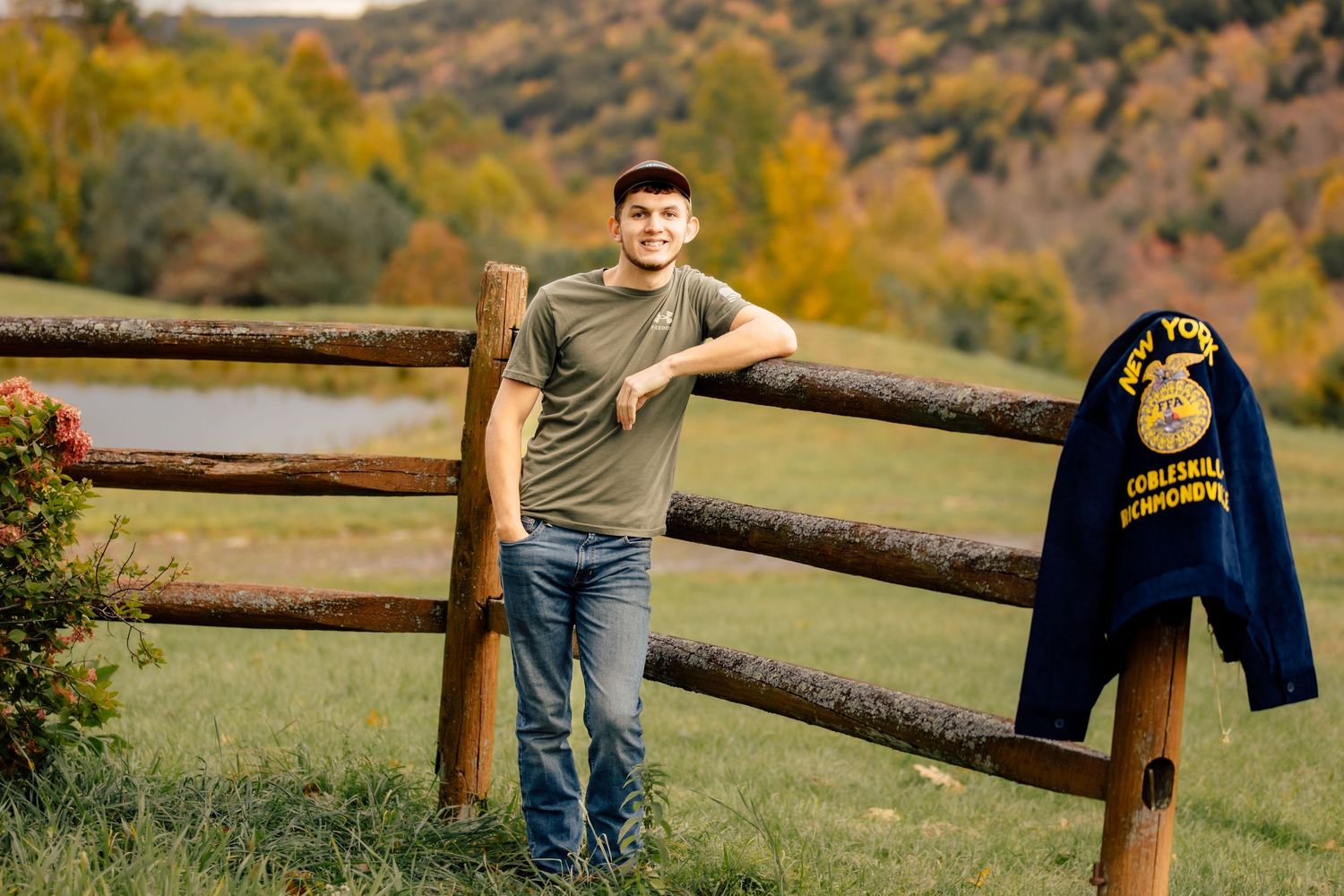 Boy leaning on fence with FFA jacket hanging on fence