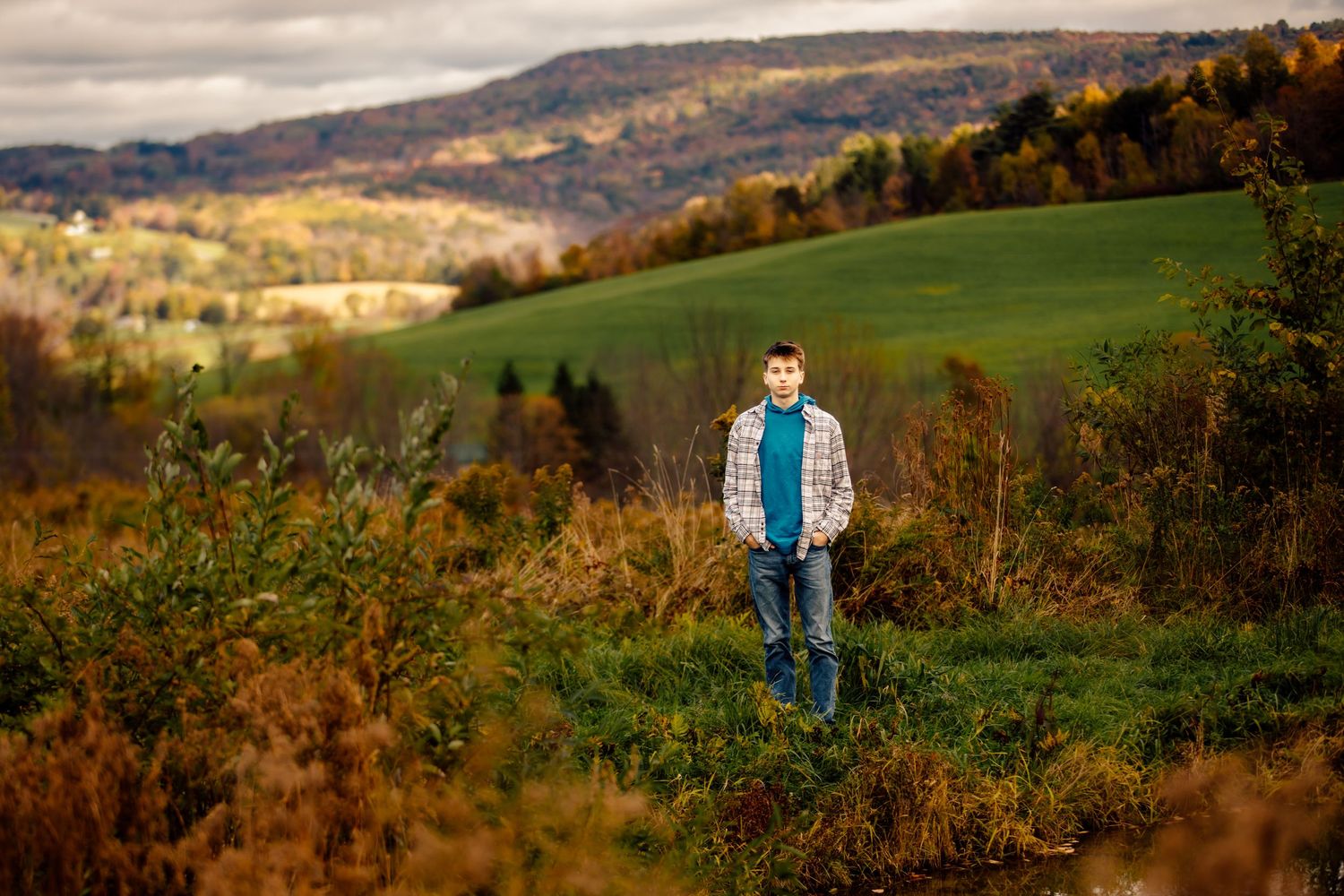 Boy standing in field with mountain view in the background