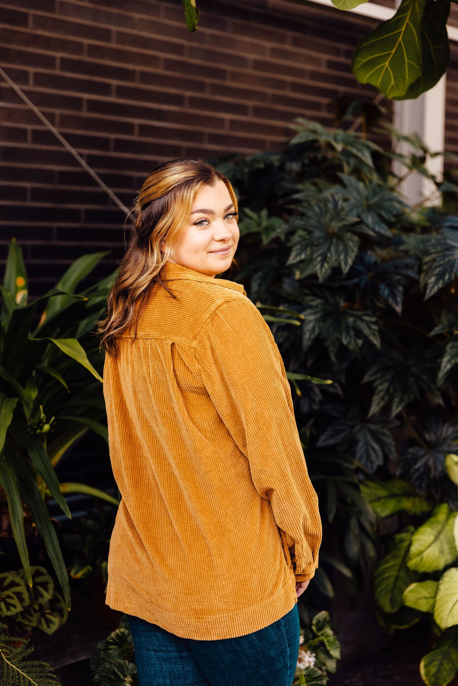 Girl looking over shoulder in greenhouse