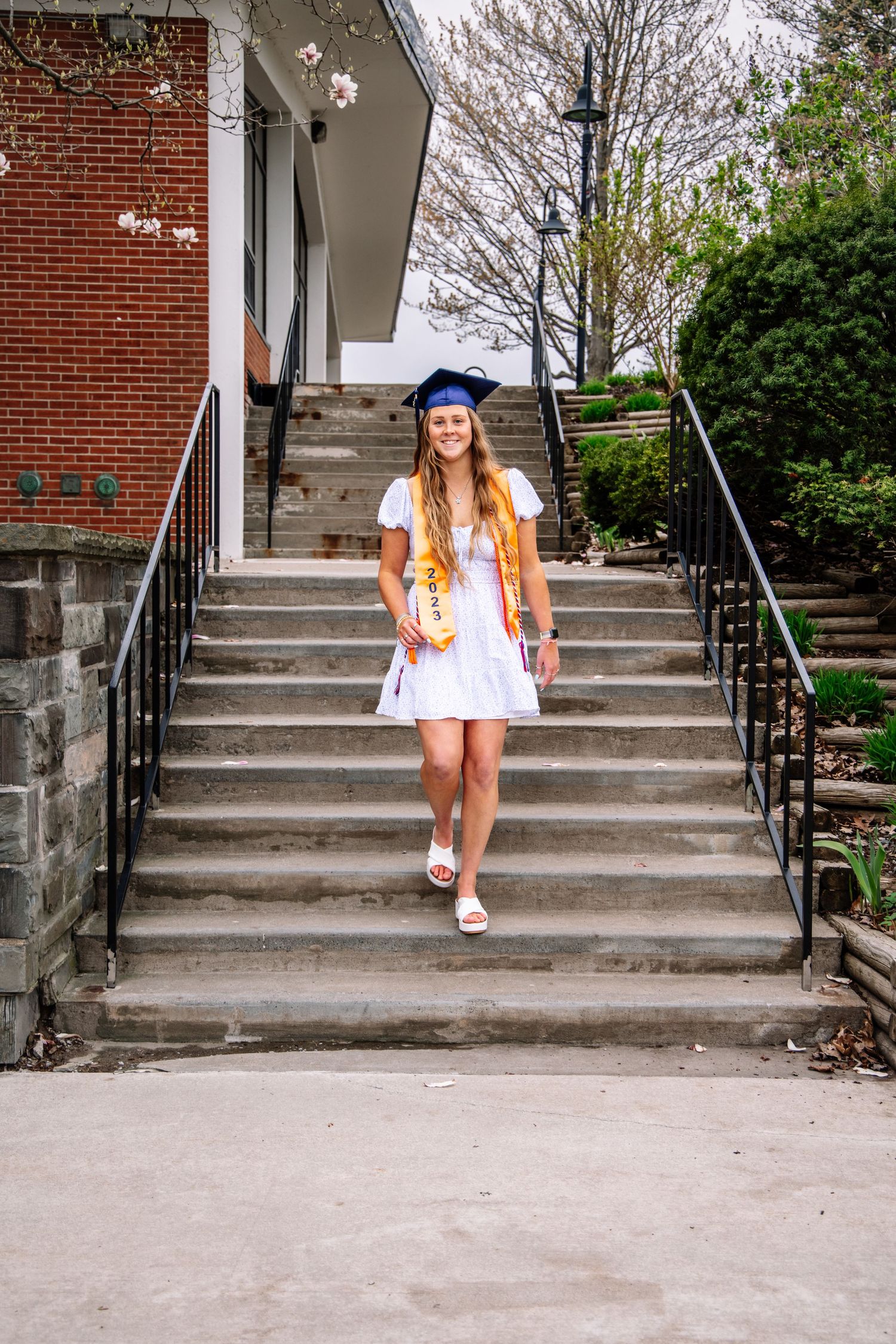 Girl wearing graduation cap walking down stairs