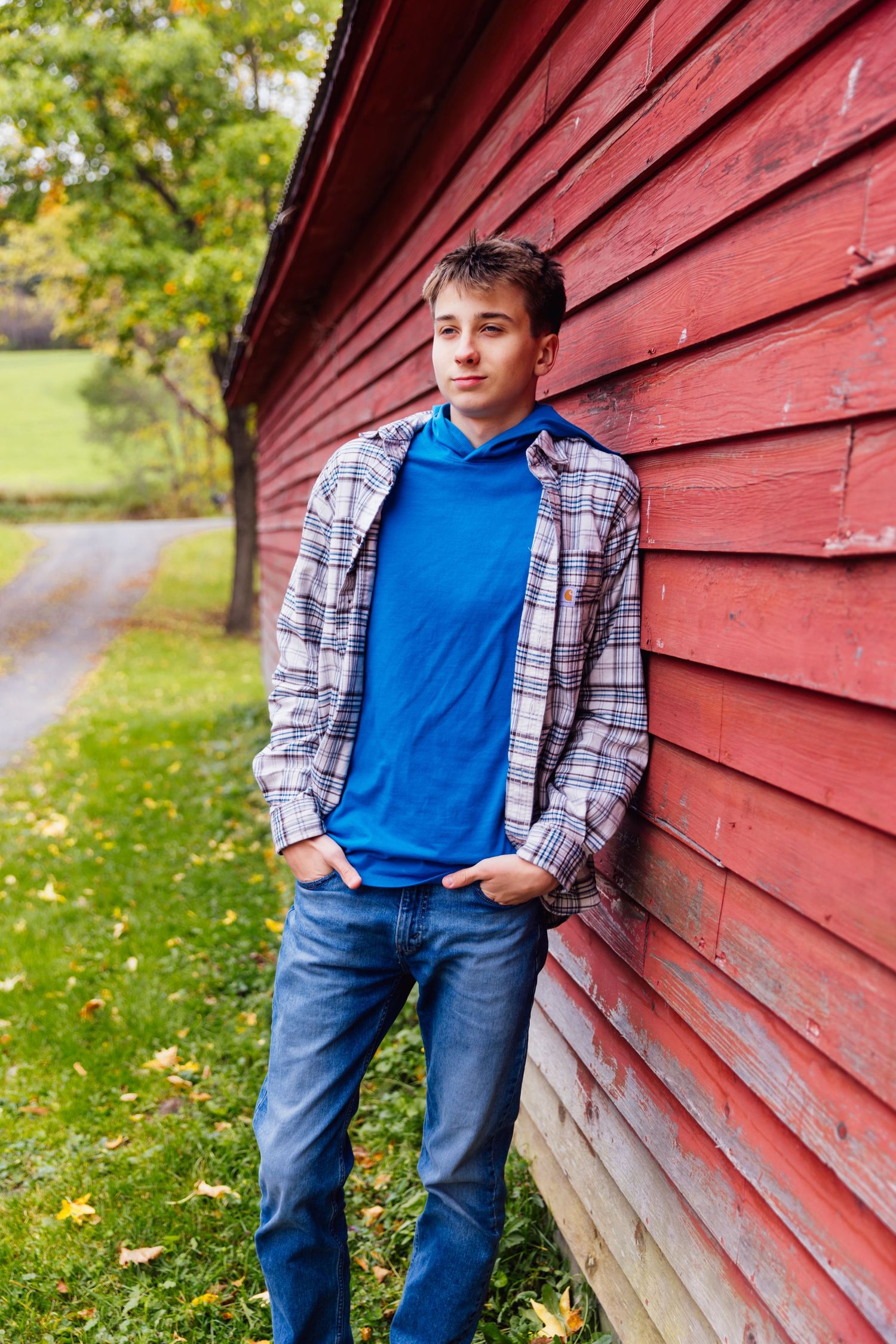 Boy leaning on red barn