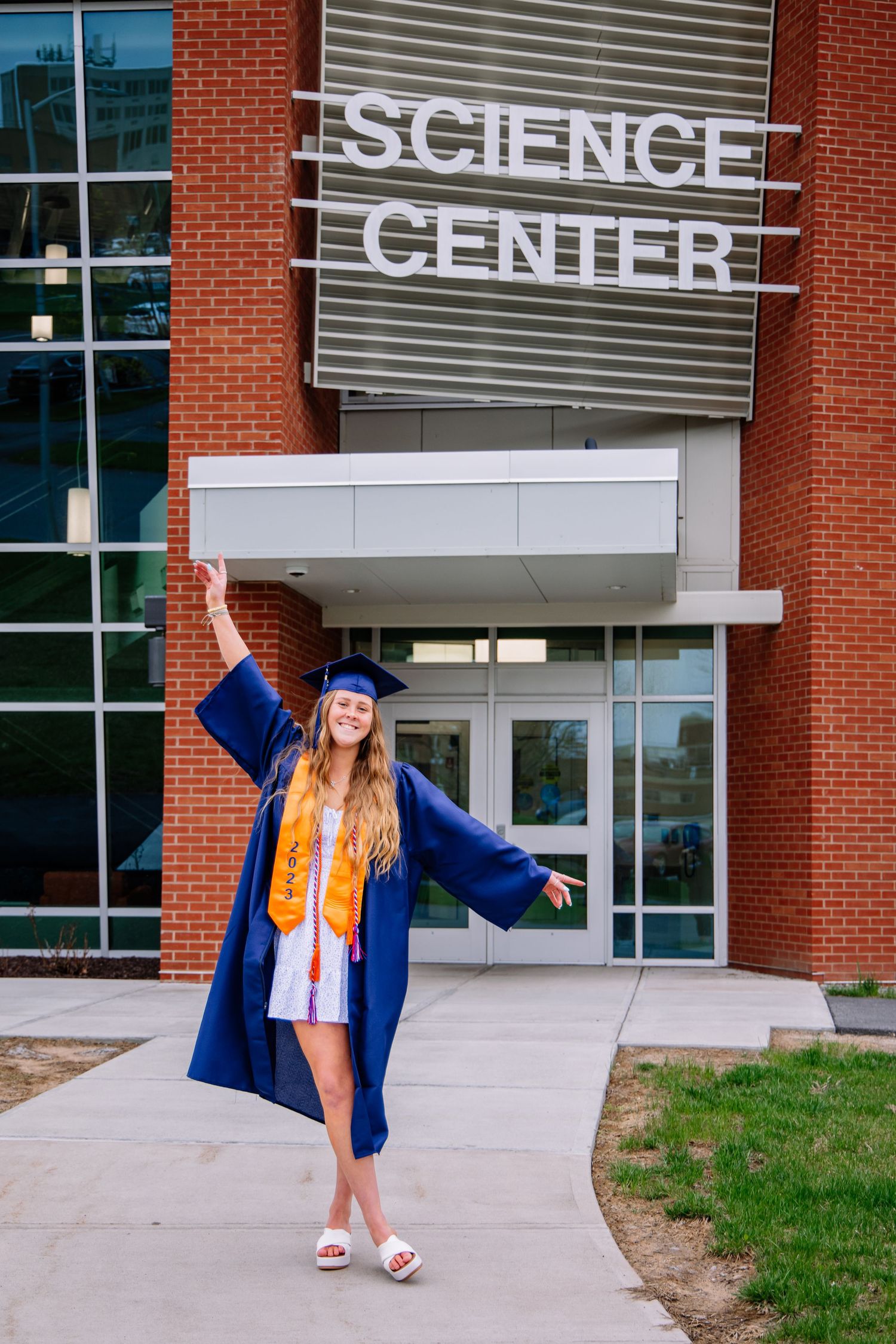Girl wearing graduation cap and gown in front of Science Center